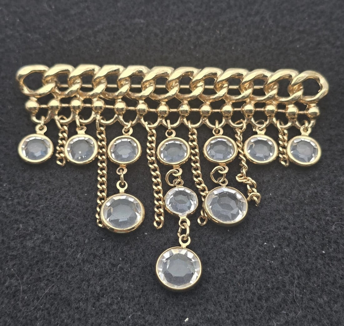 Vintage Gold Tone Curb Chain Waterfall Brooch with Clear Rhinestones: A striking vintage gold-tone statement brooch featuring a heavy curb-chain style bar top. It is designed with a cascading tiered fringe of multi-length dangle chains, each ending in a bezel-set facete