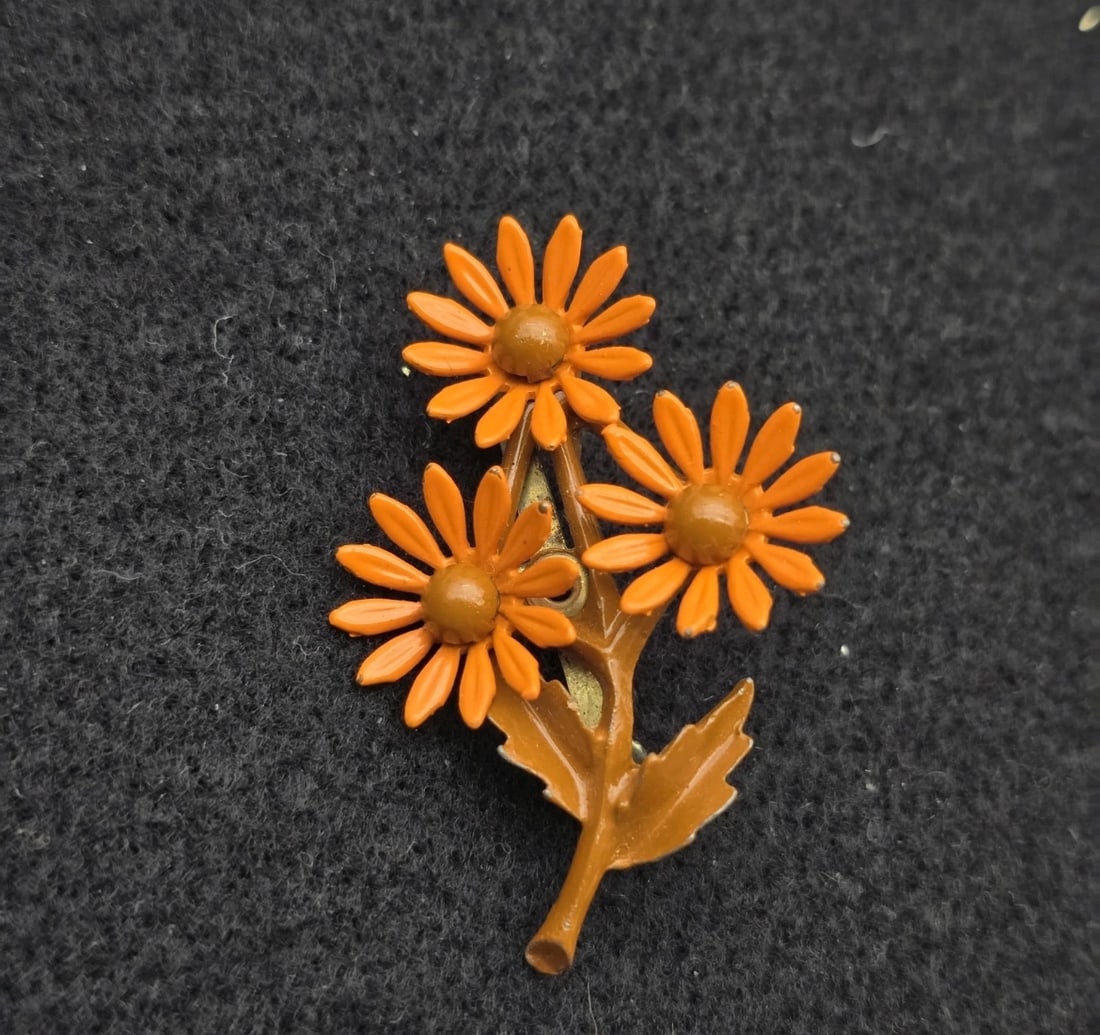 Vintage Orange Brown Flower Brooch Pin Retro Daisy Bouquet 1960's: Features three blooming daisy-style blossoms painted in a bright mod orange with dark orange centers, all clustered together on a light brown enamel stem complete with a single textured leaf.