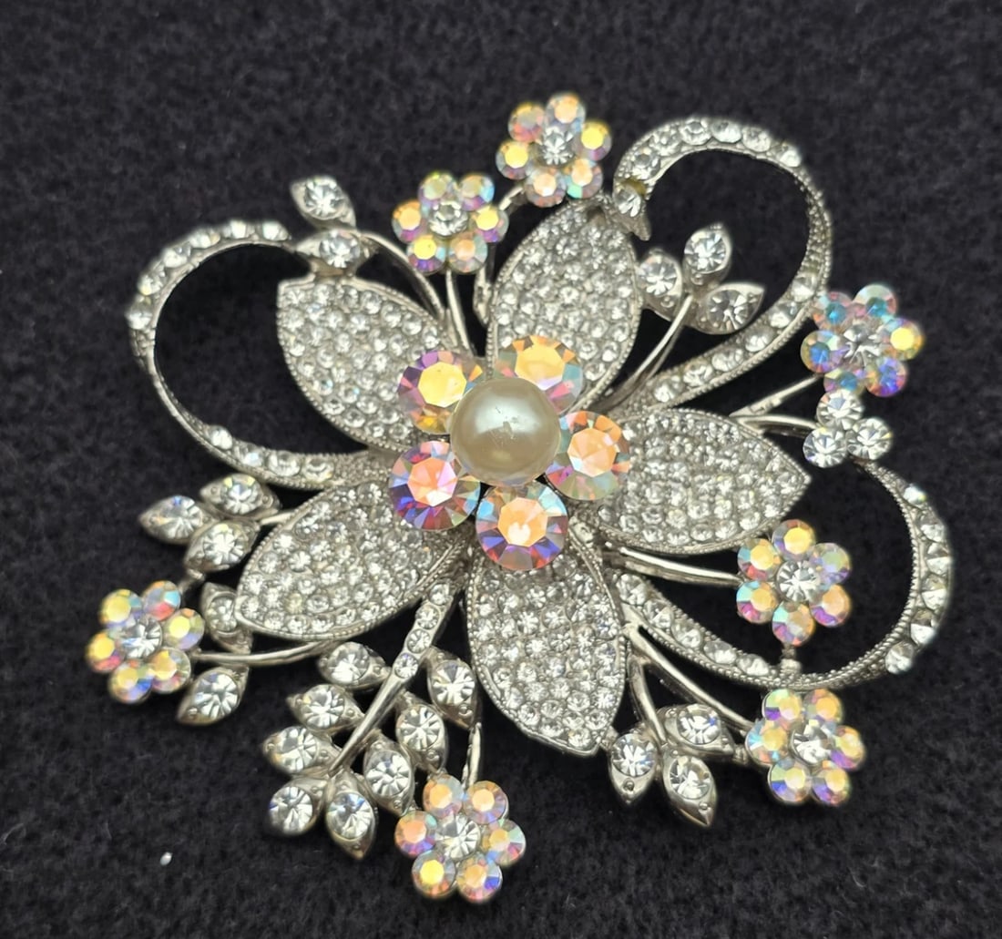 Vintage Retro Clear & AB Crystal Flower Brooch with Pearl Center: floral brooch. Features larger teardrop petals densely packed with pavé-set clear crystals, surrounded by delicate blooming wire stems holding iridescent Aurora Borealis rhinestone flowers and a cent