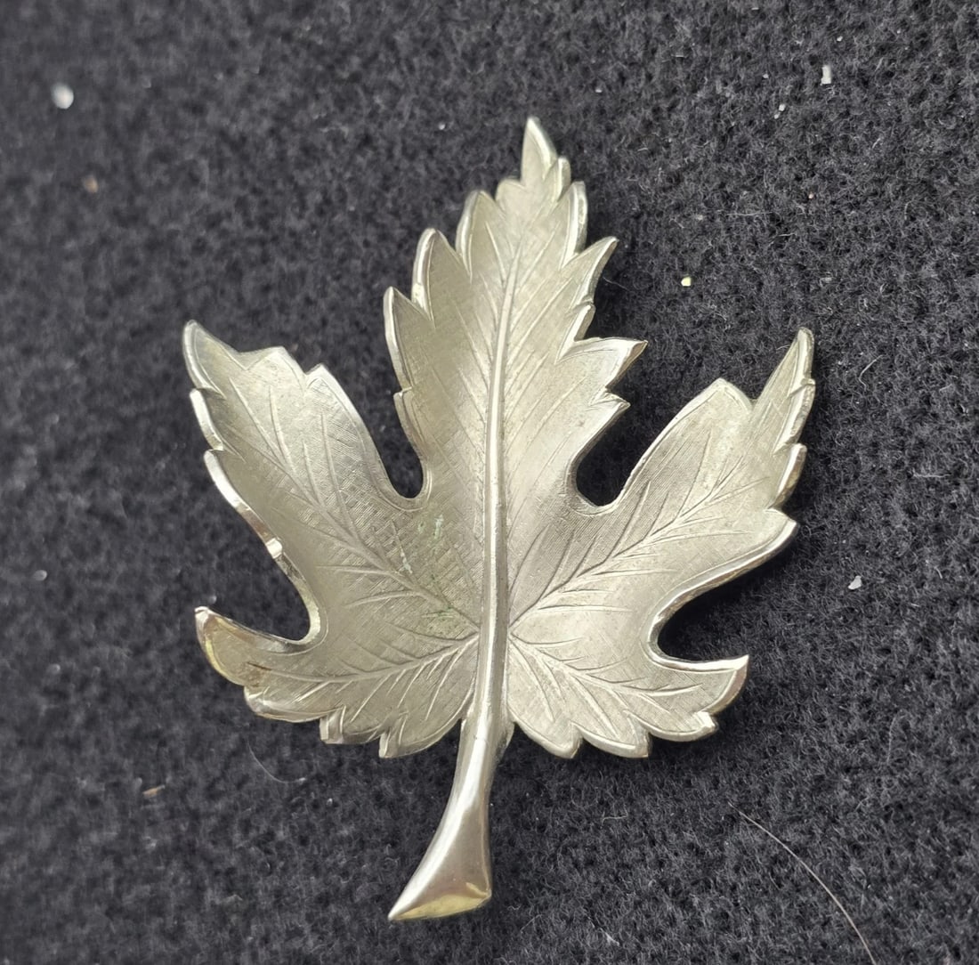 Vintage Giovann Leaf Brooch Pin 2 Tone Silver: elegant vintage silver-tone maple leaf pin. Crafted with a finely detailed brushed or silken texture across the entire surface of the leaf, accented by a contrasting highly polished silver-tone centra