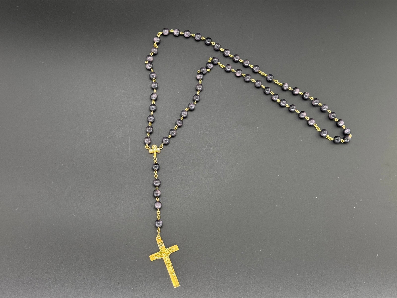 Pre-owned 14K Solid Gold Blue Goldstone Rosary Necklace With Crucifix & Zirconia Accents: 1. Pre-owned- 14K Solid Gold Blue Goldstone Rosary Necklace with Crucifix & Zirconia Accents- Chains and smaller cross is gold as well.2. All stamps hallmarks or markings are shown as received and