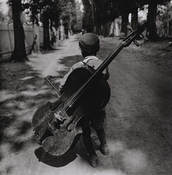 BESNYÖ, Eva (1910-2003).: BESNYÖ, Eva (1910-2003). Boy with bass, Hungary. Silver print, with the photographer's copyright stamp on the reverse 'Eva Besnyö Fotografe gkf Vondelstraat 92 Amsterdam tel. 123767'. 1931, printed
