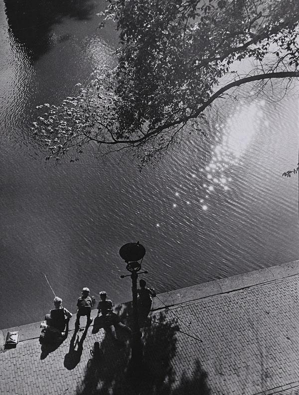 BESNYÖ, Eva (1910-2003).: BESNYÖ, Eva (1910-2003). Fishing boys, Leidsekade Amsterdam. Silver print, with the photographer's copyright stamp on the reverse 'Eva Besnyö Fotografe gkf Vondelstraat 92 Amsterdam tel. 123767'. 19