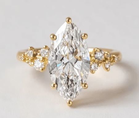 4.20 Carat Lab Grown Marquise Diamond Cluster Engagement Ring in 14kt Yellow Gold: 4.20 Carat Lab Grown Marquise Diamond Cluster Engagement Ring in Yellow Gold On each side, delicate diamond clusters are placed along the shoulders, adding soft sparkle without distracting from the ce
