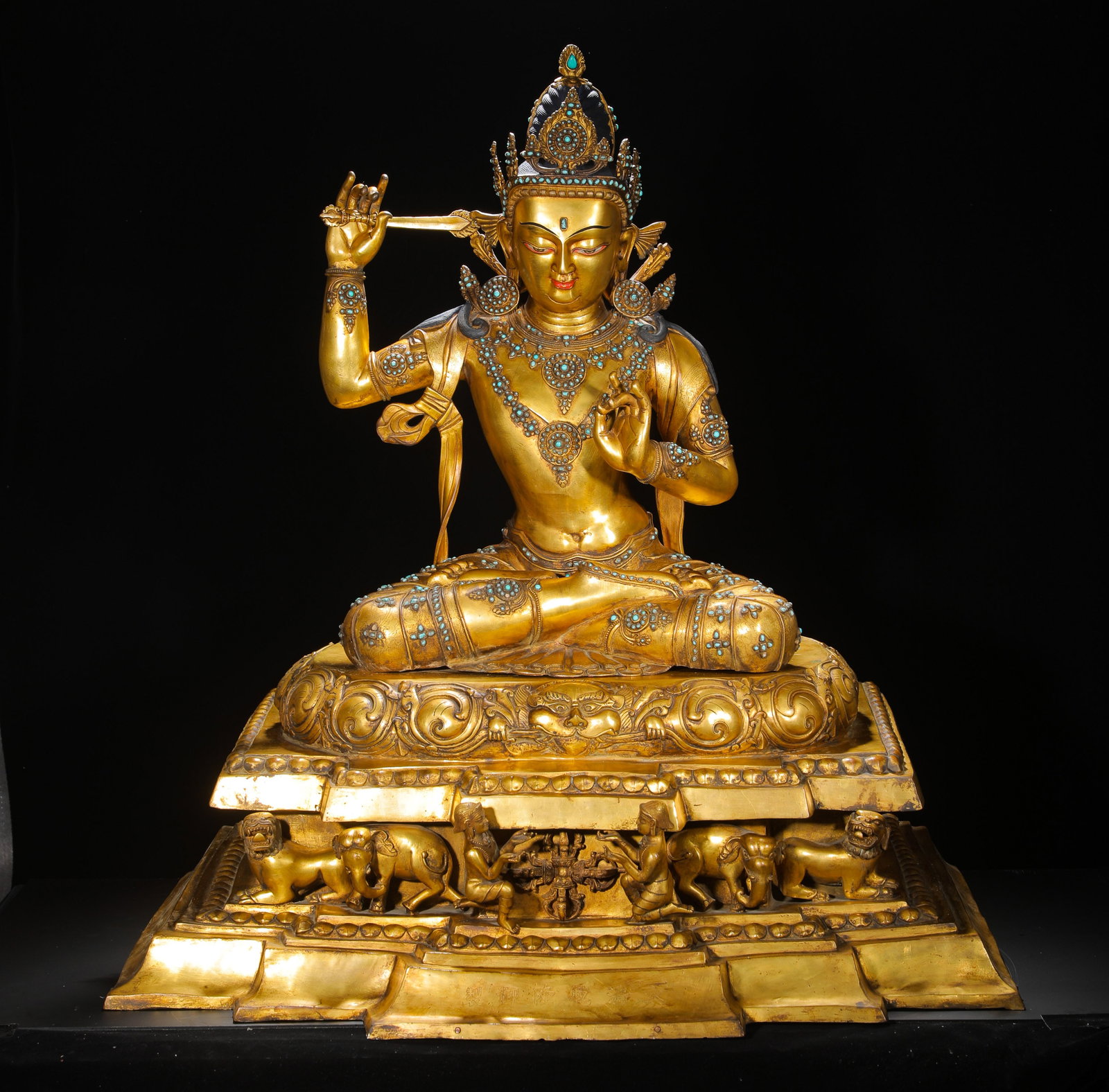A GILDED BRONZE STATUE OF MANJUSRI BODHISATTVA INLAID WITH TURQUOISE FROM THE QING DYNASTY: H:93cmW:81cmWeight:53000g Full gilded bronze seated Manjushri, bodhisattva of wisdom in Tibetan Buddhism, turquoise inlaid ornament.