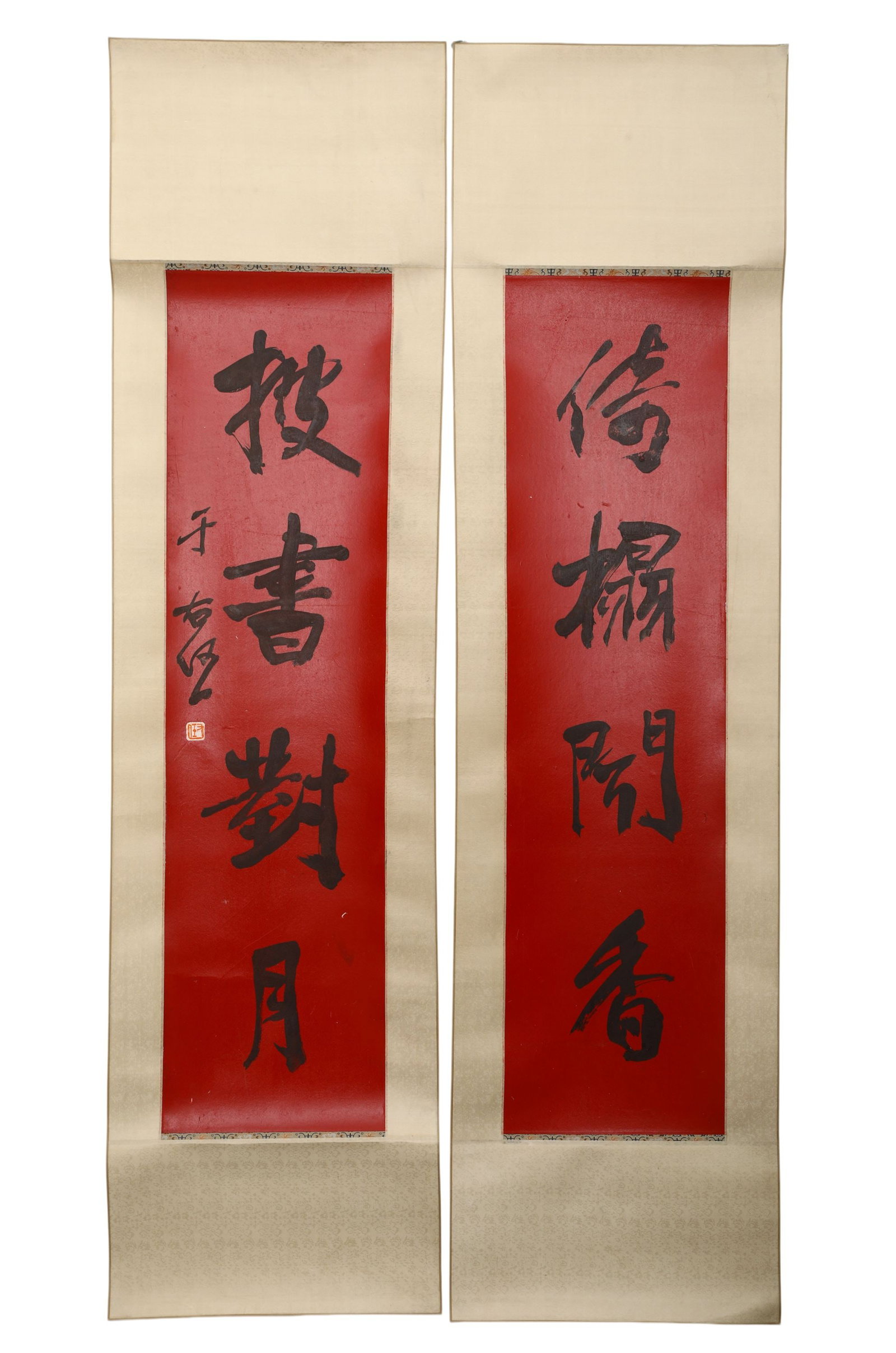 YU YOUREN (1879-1964) RUNNING SCRIPT FOUR-CHARACTER STUDY COUPLET RED WAX PAPER STANDING SCROLL: H:105cm (41.34in) W:27cm (10.63in)Matching calligraphy couplet mounted with pale patterned silk, written on vintage red waxed rice paper with rich dark ink.Right scroll: Smell incense leaning on the c