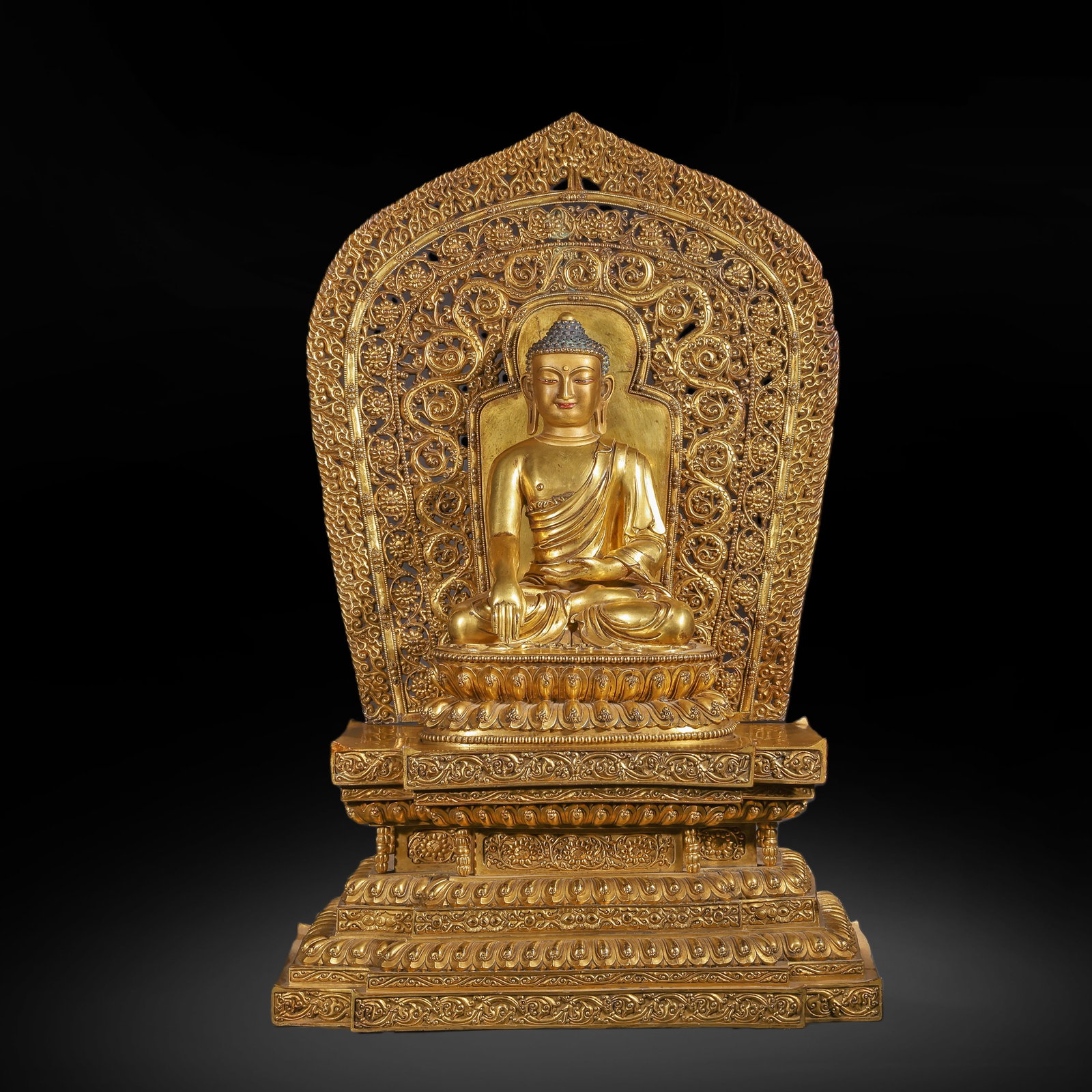 A GILDED BRONZE STATUE OF THE ENLIGHTENMENT OF SAKYAMUNI BUDDHA FROM THE QING DYNASTY: H:75.0cm(29.53in) W:44.0cm(17.32in) Weight:43150g(95.13lb)This statue is cast in bronze and gilded. The main figure Sakyamuni Buddha sits in the full-lotus posture on a double-layered lotus pedestal, 
