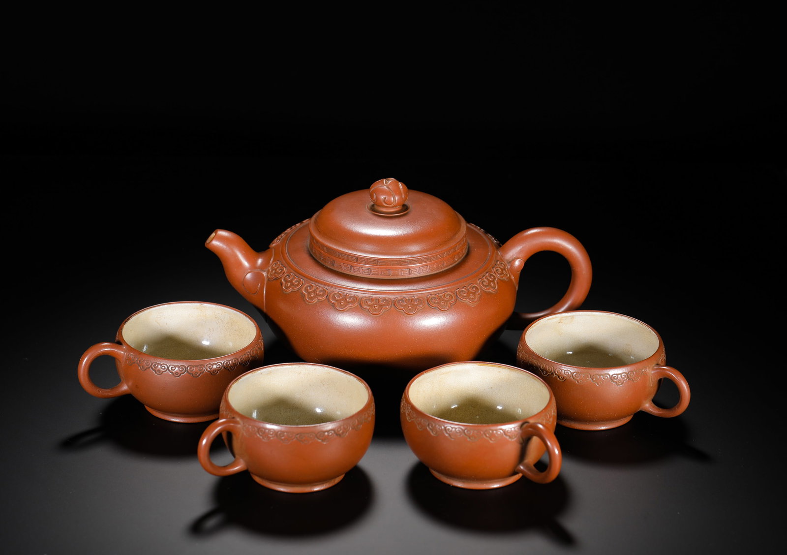 GU JINGZHOU PURPLE CLAY TEAPOT: H:14cm(5.51in)W:24.5cm(9.65in)Weight:1340g(2.95lb)The teapot and cups feature ruyi patterns, with smooth lines and distinct layers. The foot bears a maker's mark