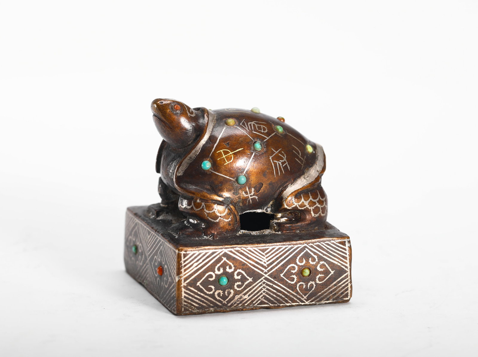 COPPER INLAID WITH GOLD AND SILVER INLAID WITH GEMSTONES TURTLE SEAL OF THE WARRING STATES PERIOD: H:4.5cm (1.77in) W:4cm (1.57in) Weight:170g (0.37lb)This is a bronze seal with a tortoise-shaped knob, decorated with silver and gold inlay and gemstone settings. The seal face bears seal script chara