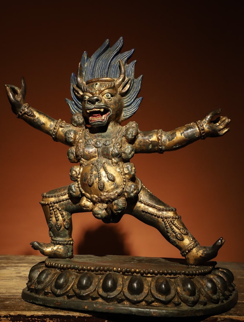 A GILDED BRONZE VAJRA STATUE FROM THE MING DYNASTY: Weight:5600gH:37cmL:32cmW:17cmThis is a Tibetan Buddhist gilt-bronze statue of a wrathful protector, depicted in a standing posture with a fierce face, protruding fangs, a flame-shaped halo on the hea