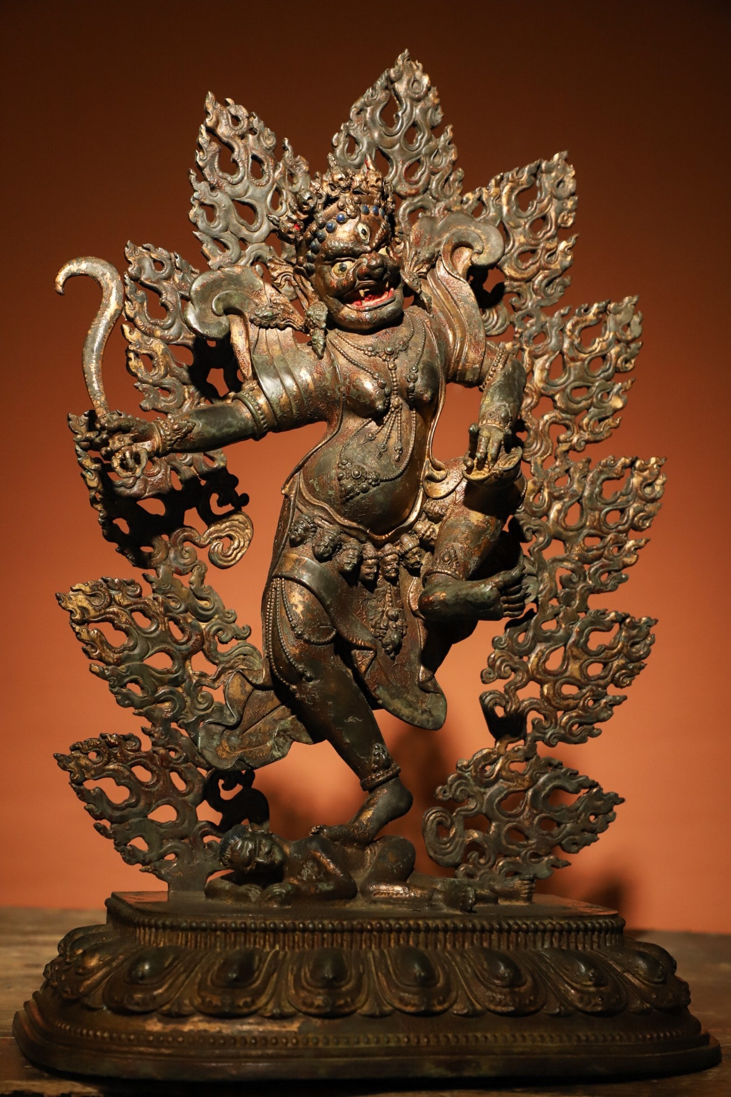 GILDED BRONZE FIGURES OF THE MING DYNASTY: Weight:4200g.H:40cmL:26cmW:14cm This is a Tibetan Buddhist gilt-bronze statue of a wrathful Dakini, depicted in a dynamic standing posture with one foot trampling a demon, surrounded by a flame-shaped
