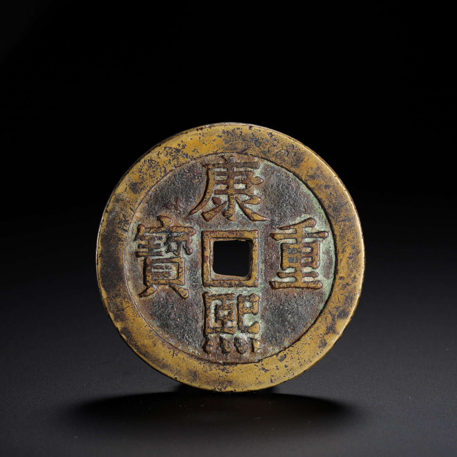 A PALACE COIN WITH DRAGON AND PHOENIX PATTERNS FROM THE REIGN OF EMPEROR KANGXI OF THE QING DYNASTY: D:6.2cmWeight:68gThis palace coin was minted during the Kangxi reign of the Qing Dynasty. The obverse bears the characters "Kang Xi Zhong Bao" in regular script, read top-bottom-right-left. The revers