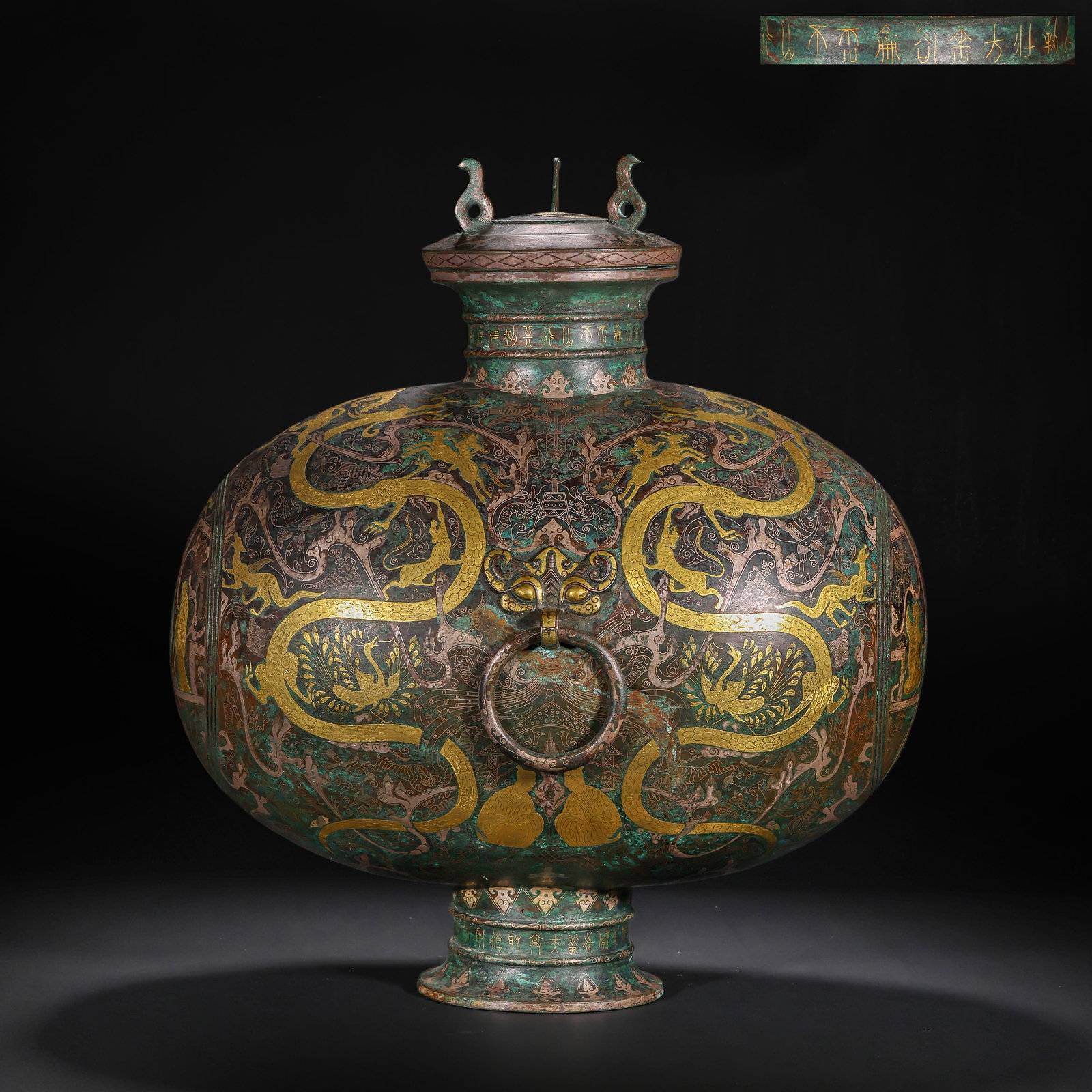 A FLAT POT WITH COPPER INLAID GOLD AND SILVER DRAGON AND PHOENIX PATTERNS FROM THE WARRING STATES: H:44.0cm(17.32in) W:37.0cm(14.57in) Weight:6890g(15.19lb)This vessel is cast in bronze, fully decorated with dragon, phoenix and auspicious beast patterns using gold and silver inlay technique. The ve