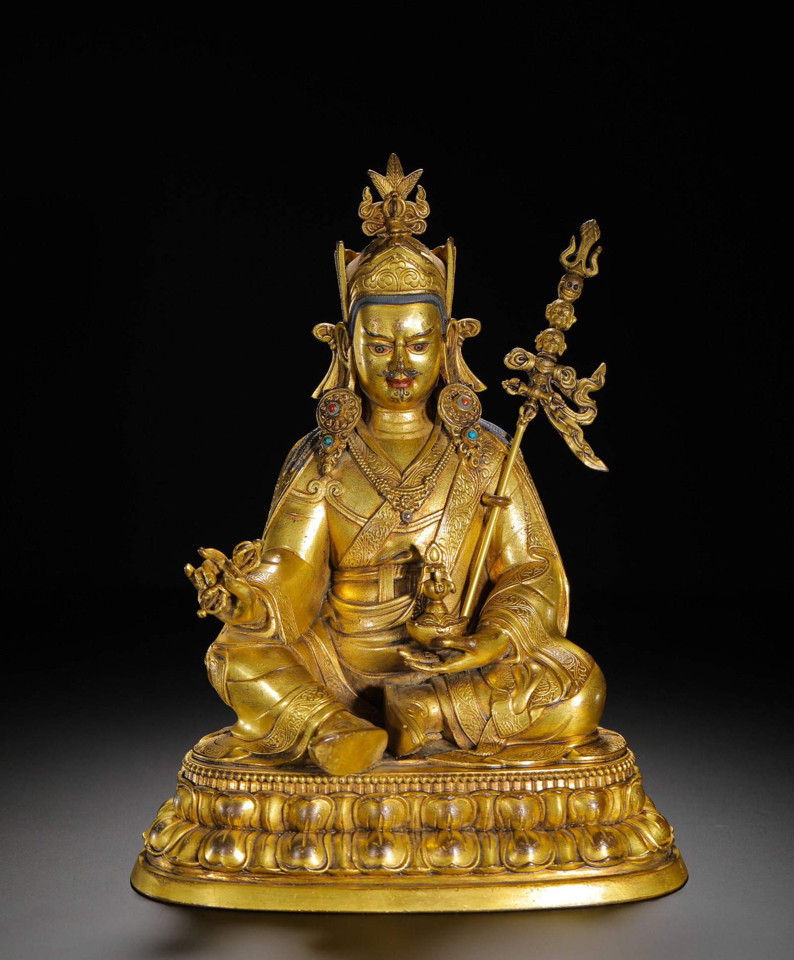 QING DYNASTY GILDED BRONZE SEATED STATUE OF PADMASAMBHAVA: H:26cm(10.24in)W:17cm(6.69in)Weight:2020g(4.45lb)As the founder of the Nyingma school, Padmasambhava is revered as a combined incarnation of the Buddhas, making this statue a highly significant religi