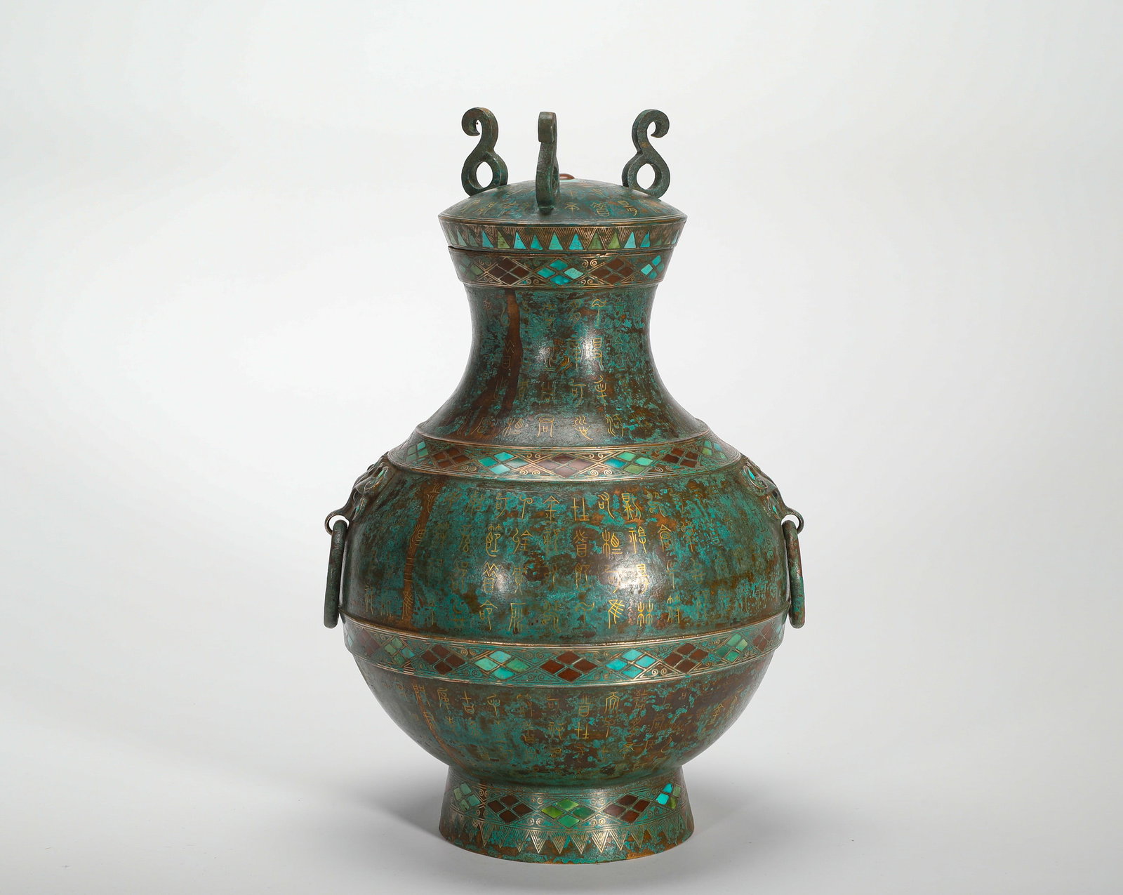 COPPER INLAID WITH GOLD AND TURQUOISE INSCRIPTION TEAPOT OF THE HAN DYNASTY: H:27cm(10.63in)W:16cm(6.30in)Weight:1940g(4.28lb)This is an exemplary ritual bronze vessel from the Warring States to Han period, used by the nobility to hold wine or water.