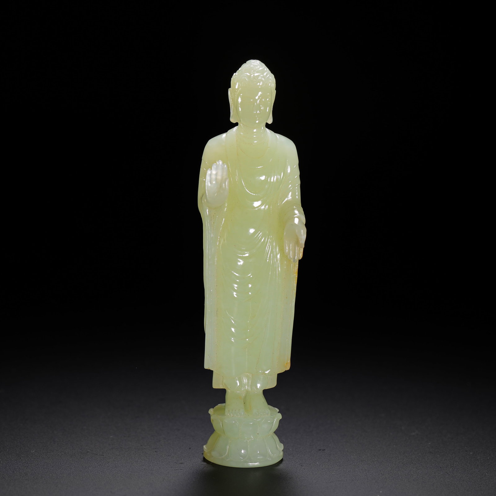 A STANDING STATUE OF SAKYAMUNI BUDDHA IN HETIAN WHITE JADE FROM THE QING DYNASTY: H:11cm (4.33in) W:3cm (1.18in) Weight:80g (0.18lb)This is a Qing Dynasty standing statue of Sakyamuni Buddha carved from Hetian greenish-white jade, with a smooth, even texture and natural light yello
