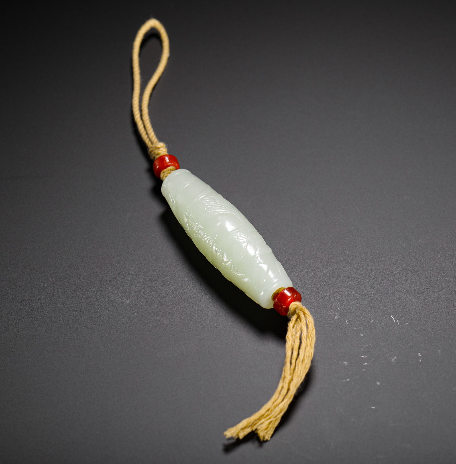 QING DYNASTY HETIAN JADE FISH-PATTERNED PENDANT: H:5.5cm (2.17in) W:2cm (0.79in) Weight:30g (0.07lb)This is a Qing Dynasty Hetian jade lezi pendant, carved from smooth greenish-white jade in an olive shape. The lezi is incised with a fish pattern, f