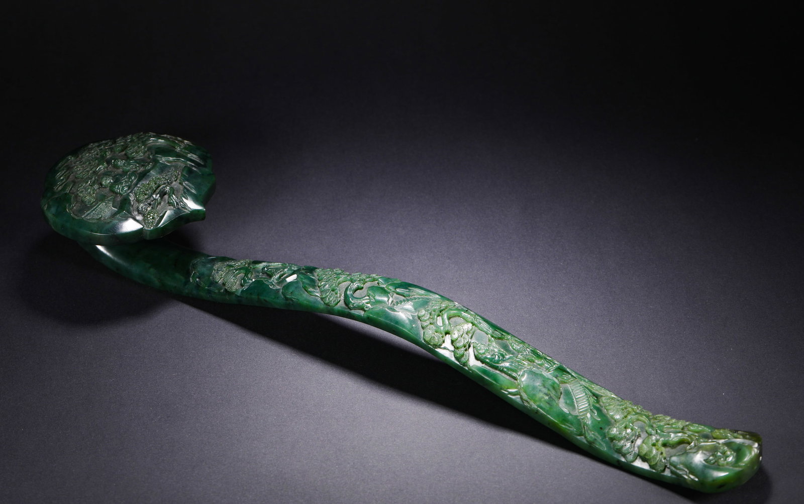 QING DYNASTY HETIAN JADE WITH LANDSCAPE AND FIGURE PATTERNS RUYI: L:40.1cm(15.79in) W:9.8cm(3.86in) Weight:733g(1.62lb)This Ruyi scepter is a masterpiece of the craftsmanship of the Qing Dynasty Imperial Workshop. Carved from top-quality Hetian green jade with a dee