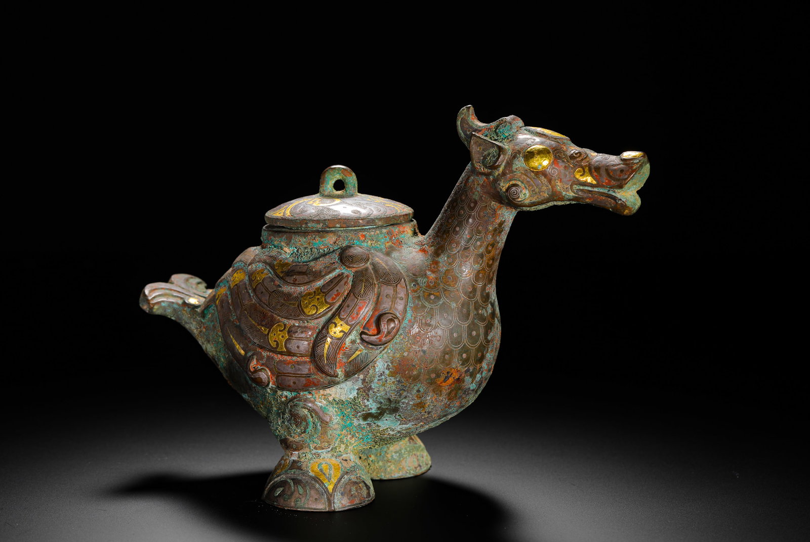 BRONZE INLAID GOLD AND SILVER BEAST SHAPE FROM THE WARRING STATES PERIOD ?: H:15cm (5.91in) W:20cm (7.87in) Weight:1370g (3.02lb)This he vessel is a Warring States Period bronze ritual object. Shaped like a mythical beast, its entire body is decorated with feather and scale p