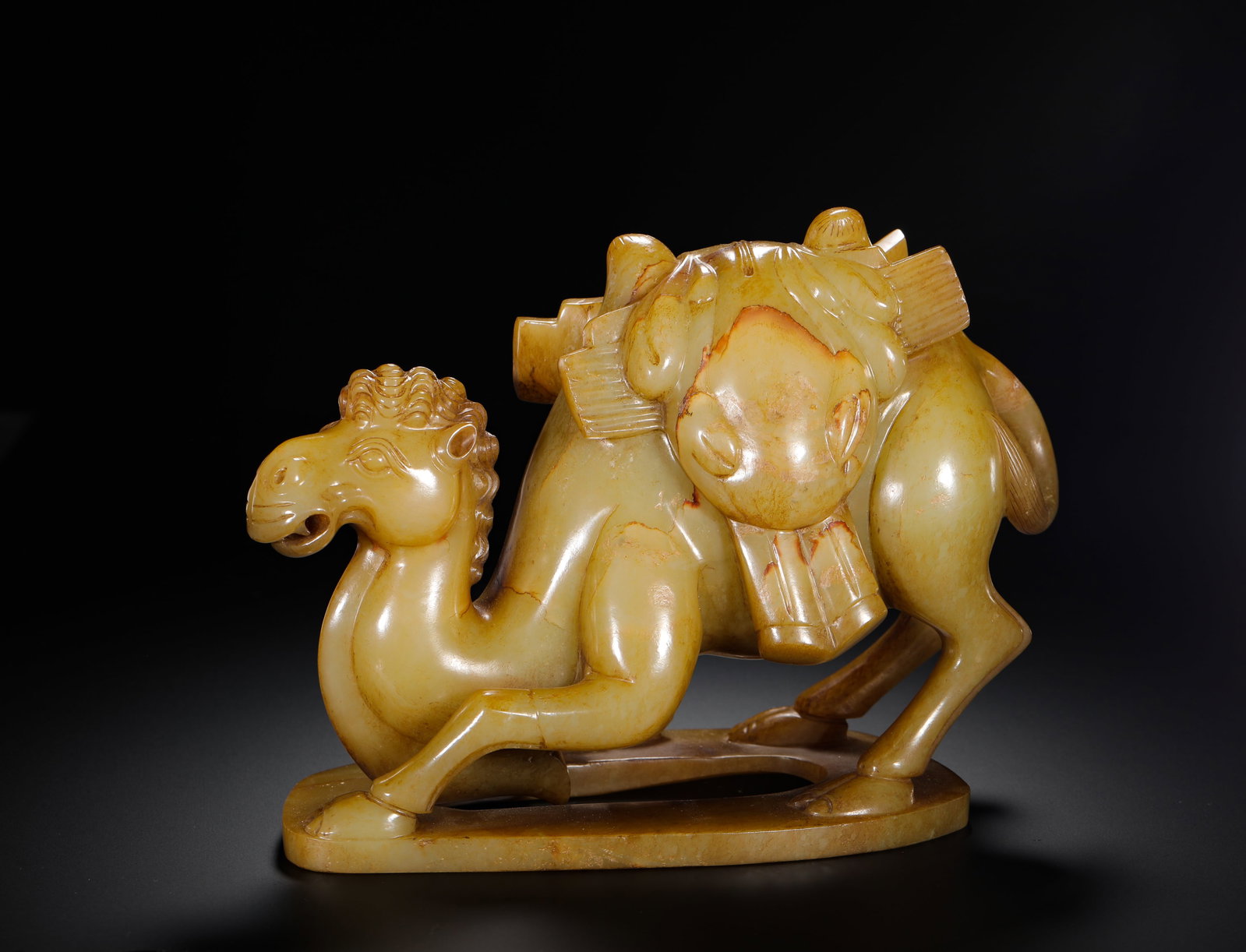 TANG DYNASTY HETIAN JADE CAMEL CARRYING ORNAMENTS: H:15cm (5.91in) W:21cm (8.27in) Weight:2230g (4.92lb)This is a Tang Dynasty Hetian jade camel ornament, carved from smooth pale yellow jade with natural patina. The camel is depicted in a