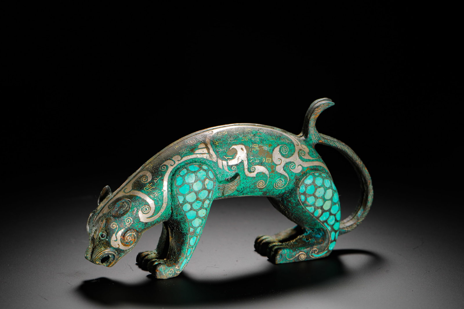 BRONZE FROM THE WARRING STATES PERIOD WITH INLAID GOLD AND SILVER AND TURQUOISE IN THE SHAPE OF A: H:9.5cm (3.74in) W:20cm (7.87in) Weight:1440g (3.17lb) This is a Warring States Period ornament. Shaped like a hunting leopard, it is decorated with intricate patterns inlaid with gold, silver, and tu