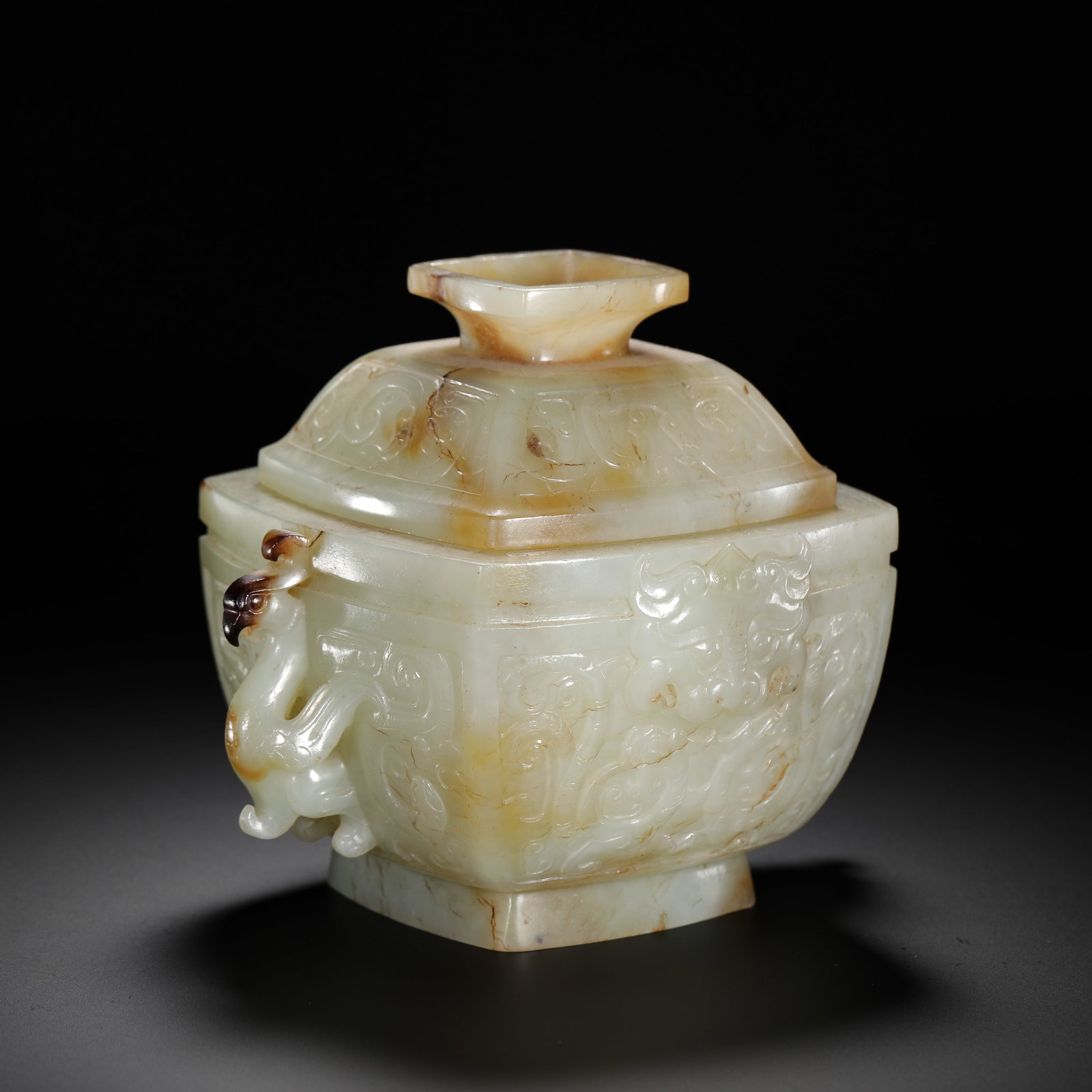 HAN DYNASTY HETIAN JADE PHOENIX EAR AND BEAST FACE PATTERNED SQUARE LID BOX: H:11cm (4.33in) W:14cm (5.51in) Weight:630g (1.39lb)This is a Han Dynasty Hetian jade square covered box, carved from smooth jade with natural patina, with some parts presenting a yellowish-brown colo