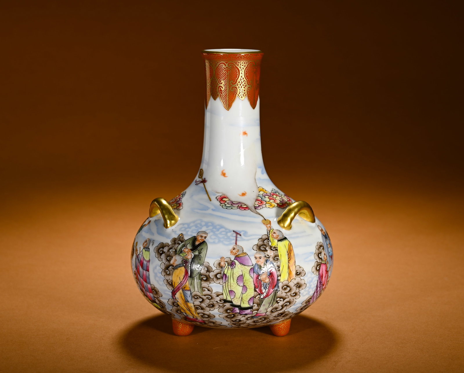 QING DYNASTY PASTEL EIGHTEEN ARHATS PATTERN THREE-LEGGED THREE-LEGGED LONG-NECKED VASE: Height:17cm(6.69in)Width:13cm(5.12in)Weight:420g(0.93lb)Famille rose long-necked vase with eighteen arhats, three handles and three feet. Qianlong shape with long neck, plump belly, three gilt loop