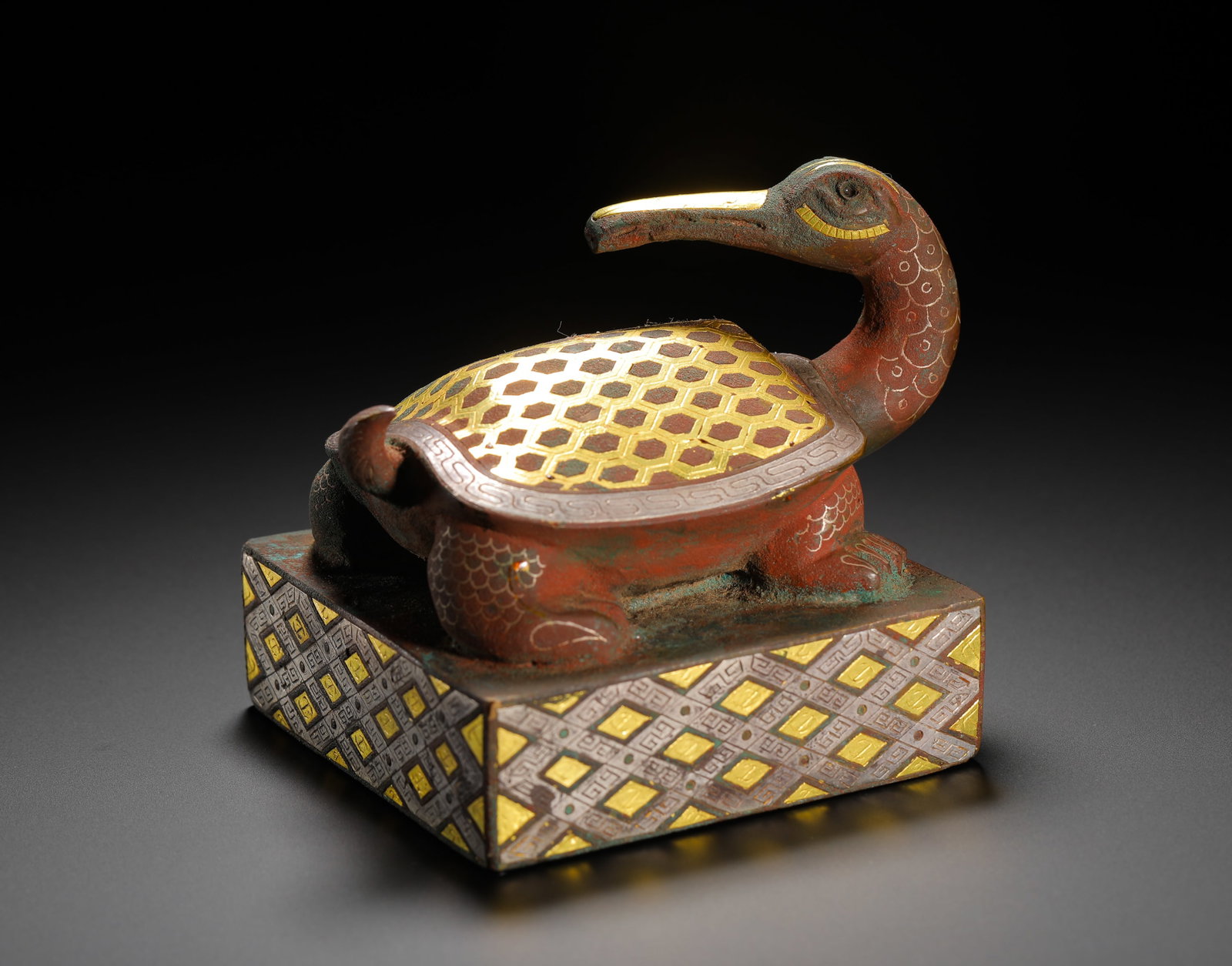 BRONZE SQUARE SEAL WITH INLAID GOLD AND SILVER BIRD HEAD AND TURTLE KNOB FROM THE WARRING STATES: Height:7.5cm(2.95in) Width:7.5cm(2.95in) Weight:800g(1.76lb)Warring States square bronze seal with gold & silver inlaid bird-head turtle knob. The turtle-shaped knob features full gold hexagonal torto