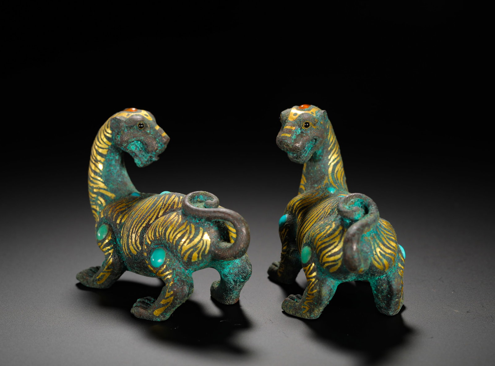 BRONZE TIGER TOWN IN PAIRS OF GOLD INLAID WITH TURQUOISE AND AGATE FROM THE WARRING STATES PERIOD: Height:7cm(2.76in) Width:9cm(3.54in) Weight:440g(0.97lb)Pair of matching Warring States bronze mat weights shaped as walking tigers. They served as aristocratic study and hall ornaments to press mat e