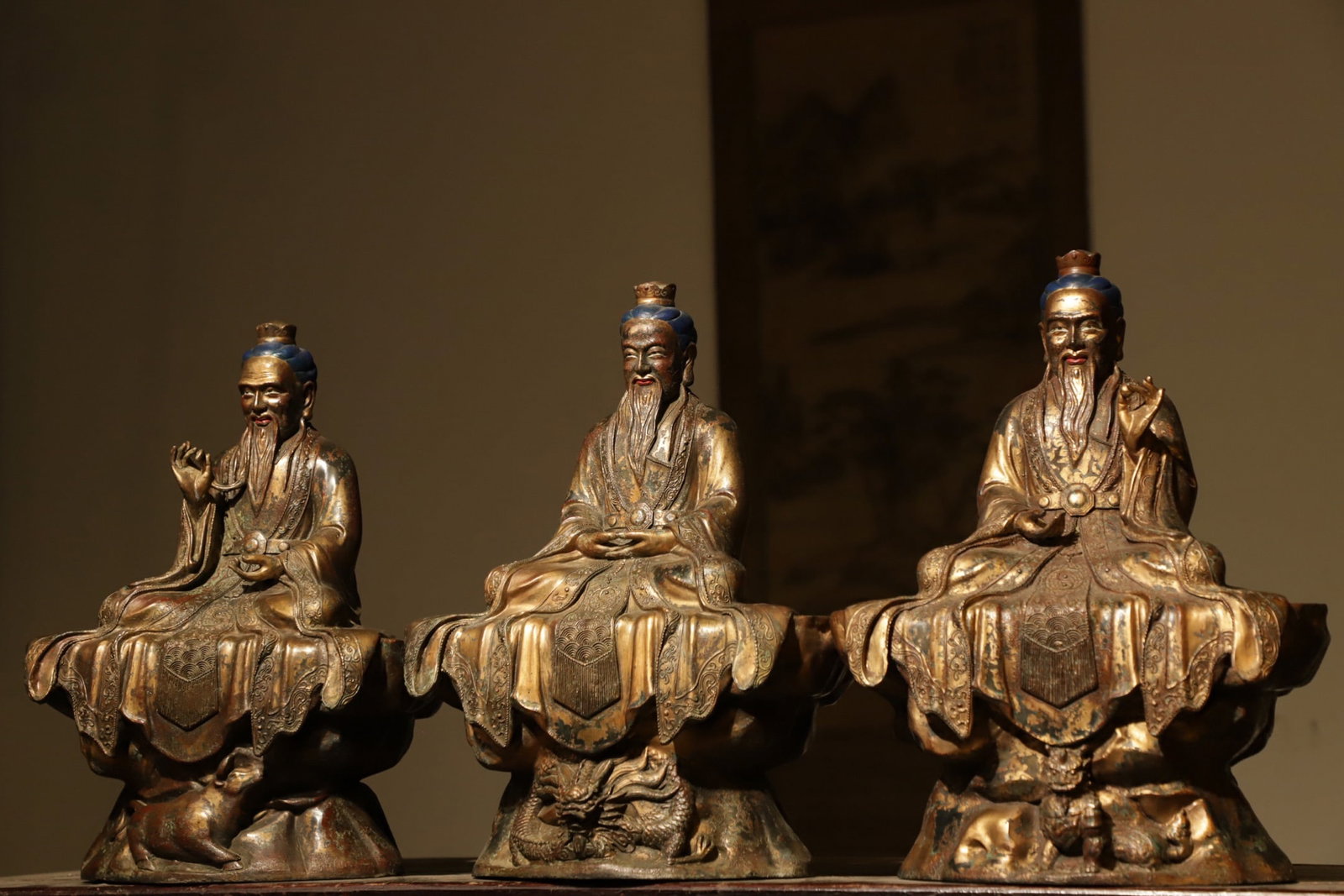A SEATED STATUE OF THE THREE PURE ONES IN GILDED BRONZE FROM THE MING DYNASTY: Weight:23250g?H:40L:30W:17cmThis is a set of gilt-bronze sitting statues of the Three Pure Ones (Sanqing), the highest deities in Taoism. Comprising Yuanshi Tianzun, Lingbao Tianzun, and Daode Tianzun
