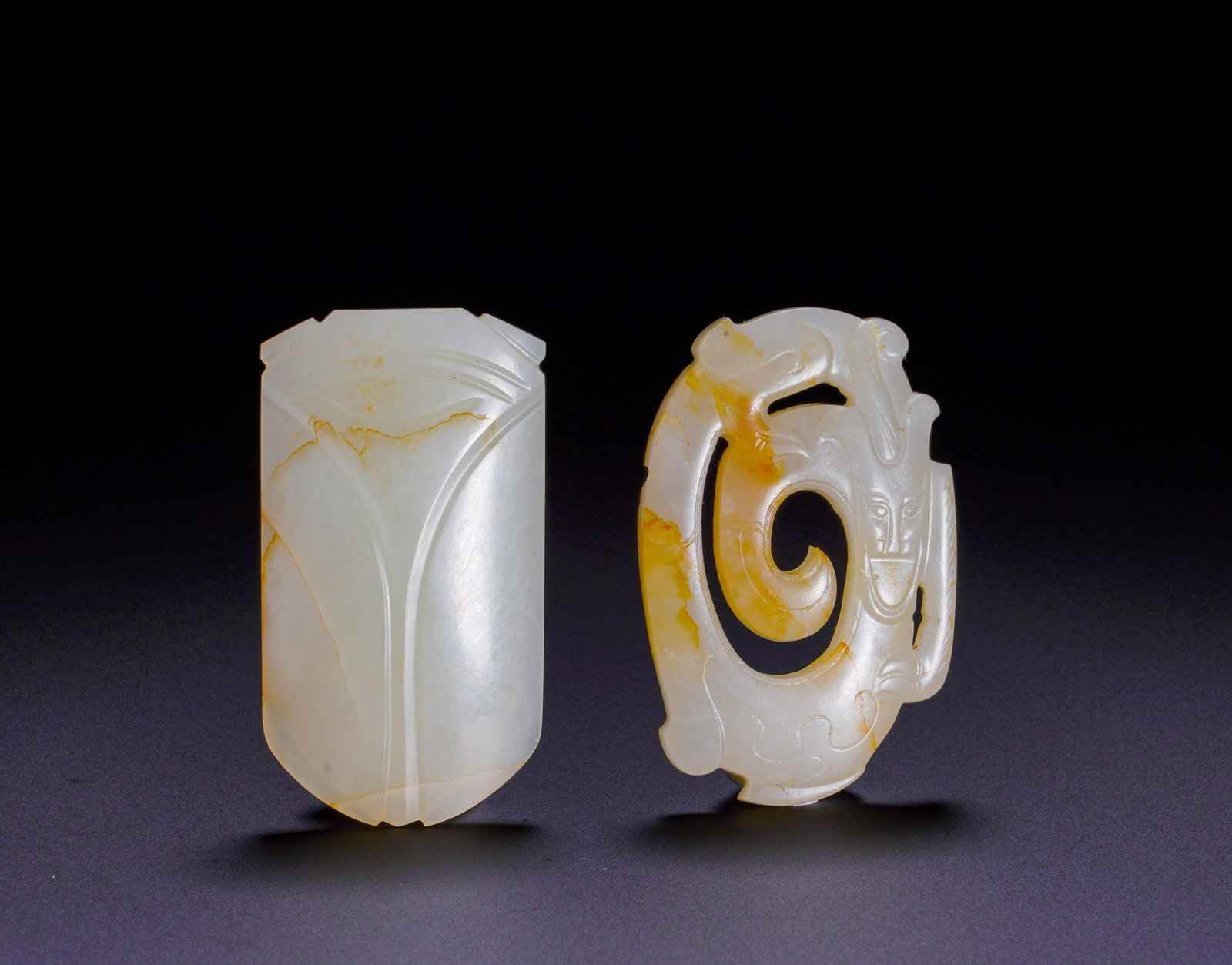 A SET OF TWO PIECES OF HAN DYNASTY JADE CICADAS AND PIERCED DRAGON-SHAPED PENDANTS: MaximumHeight:5.1cm(2.01in)Width:2.9cm(1.14in)Weight:40g(0.09lb)Han Dynasty jade cicada and openwork dragon pendant, set of two pieces.The left jade cicada is crafted from white jade with natural yell