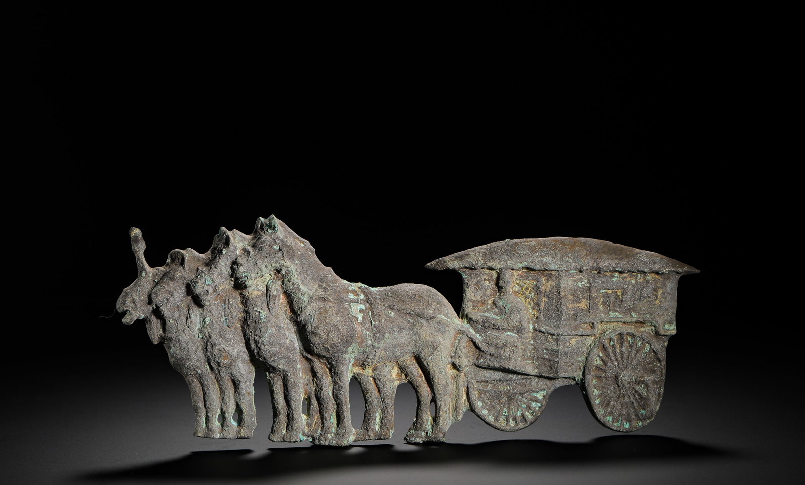 BRONZE FOUR-HORSE CHARIOT PLAQUE OF THE HAN DYNASTY: Height:9.5cm(3.74in) Width:26cm(10.24in) Weight:610g(1.34lb)Flat bronze plaque carved with four horses pulling covered carriage. Thin bronze sheet fully covered with green ancient copper rust patina.