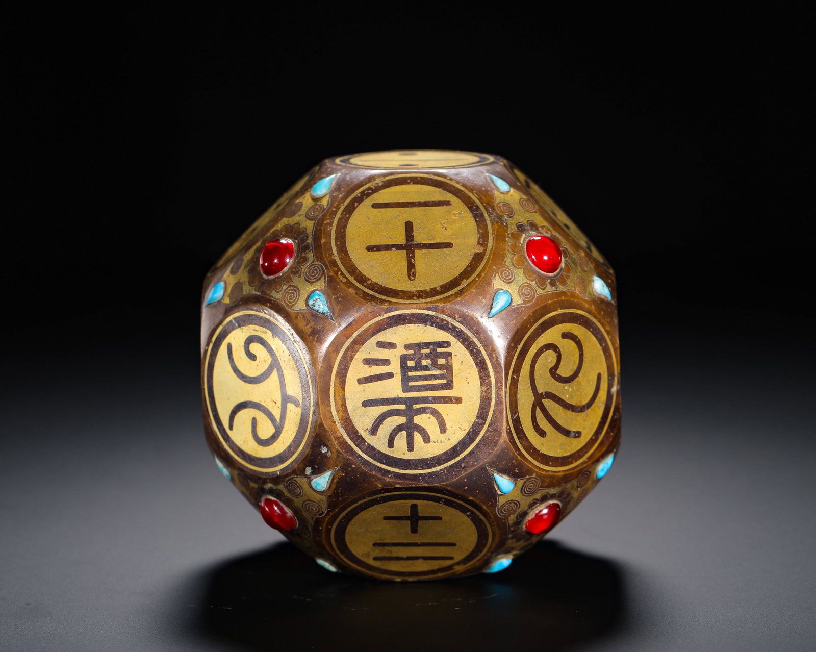 COPPER BODY WITH GOLD INLAID AND GOLD INLAID WINE DICE: D:9.5cm(3.74in) Weight:920g(2.03lb)Eighteen-sided bronze drinking dice inlaid with gold wire and gemstones. Bronze base carved with gold incised numerals, "wine" character and chi-dragon patterns on e