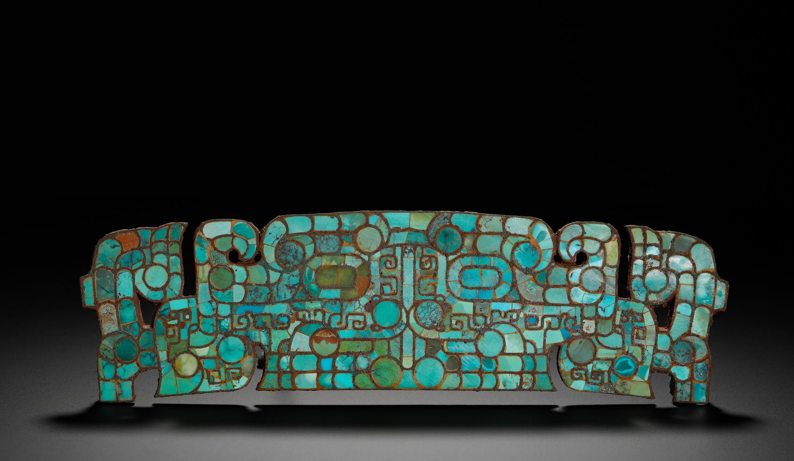 SHANG AND ZHOU DYNASTY BRONZE INLAID WITH TURQUOISE ANIMAL FACE PATTERNS LONG PLAQUE DECORATION: Height:7cm(2.76in) Width:25cm(9.84in) Weight:500g(1.10lb)Shang-Zhou bronze plaque inlaid with turquoise beast-face patterns, covered with symmetrical primitive mask motifs on front, burial rust and