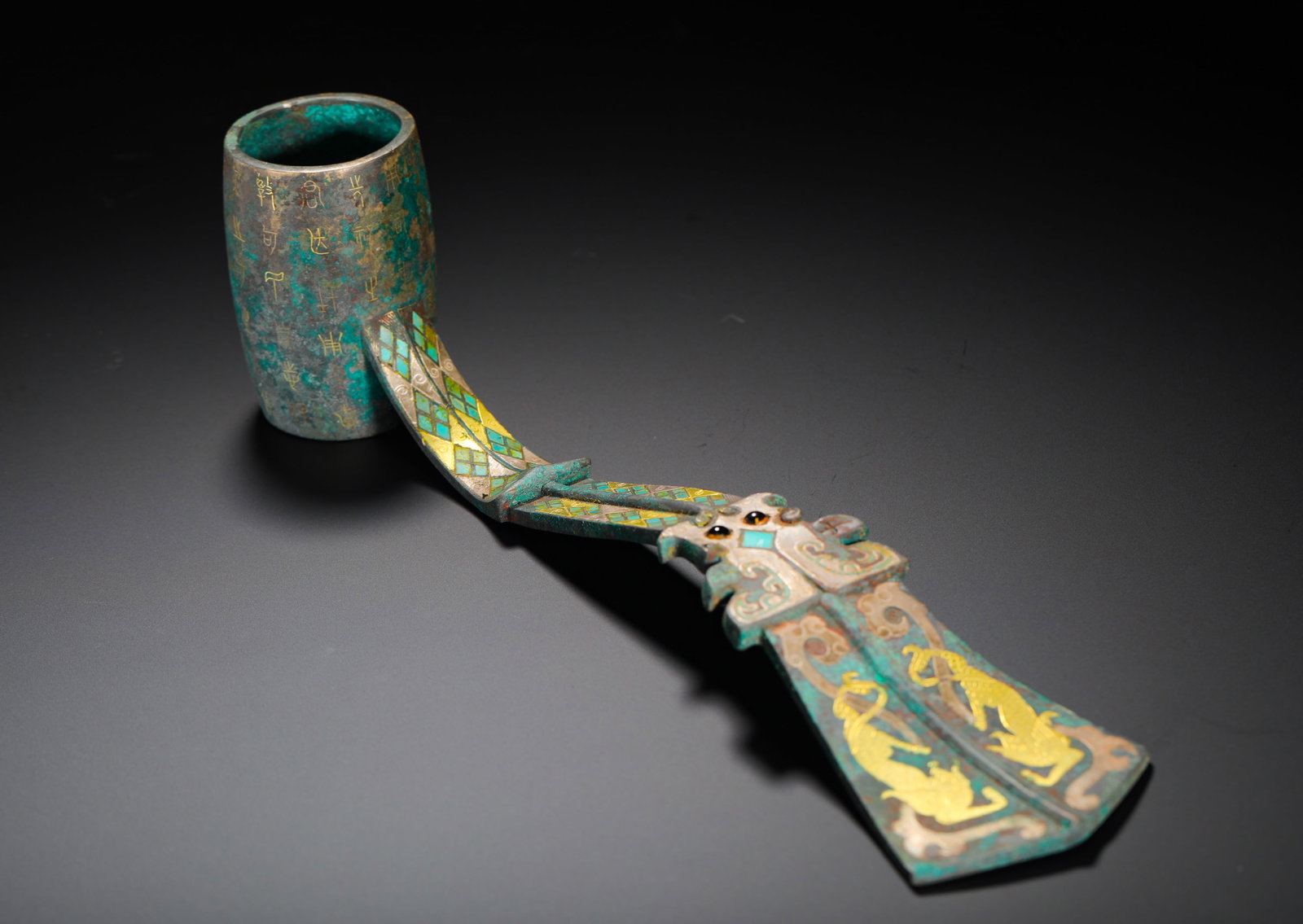 BRONZE OF THE WARRING STATES PERIOD WITH INLAID GOLD AND SILVER INLAID TURQUOISE BEAST PATTERNS FOR: Height:8cm(3.15in) Width:31.5cm(12.40in) Weight:740g(1.63lb)Warring States bronze wine ladle inlaid with gold, silver, turquoise and twin beast patterns, inscribed golden characters on barrel, a