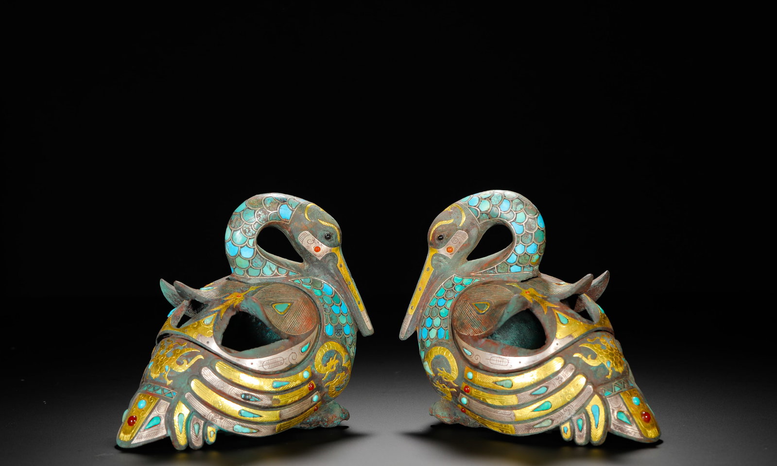 HAN DYNASTY BRONZE INLAID GOLD AND SILVER INLAID TURQUOISE MANDARIN DUCK INCENSE BURNER: Height:13cm(5.12in) Width:16cm(6.30in) Weight:1790g(3.95lb)A pair of Han Dynasty bronze mandarin duck censers inlaid with gold, turquoise and red gemstones, separable hollow bodies for burning incense