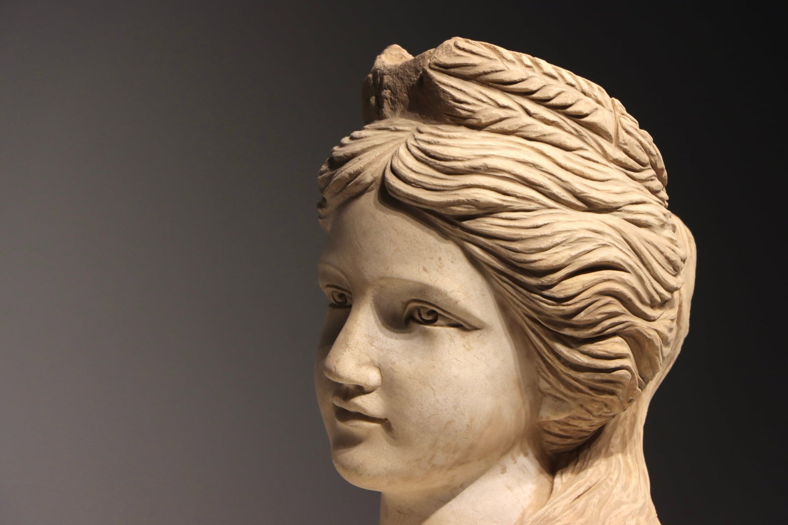 ANCIENT GREEK STATUES: H:34cm(13.39in)A fragmentary classical Western marble head of goddess, exquisitely carved with swirling wavy hair, gentle and elegant facial features with broken crown on top, a representative realist