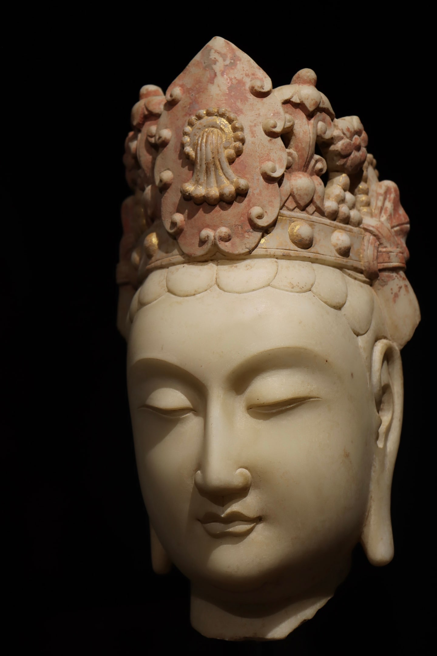 THE HEAD OF THE BODHISATTVA GUANYIN PAINTED WITH WHITE MARBLE FROM THE SUI DYNASTY: Height:29cm(11.42in)?Height:49cm(19.29in)Antique Sui-Tang white marble Avalokiteshvara head, faded gold and red pigment, relic of grotto-style statue embodying mercy and blessing.
