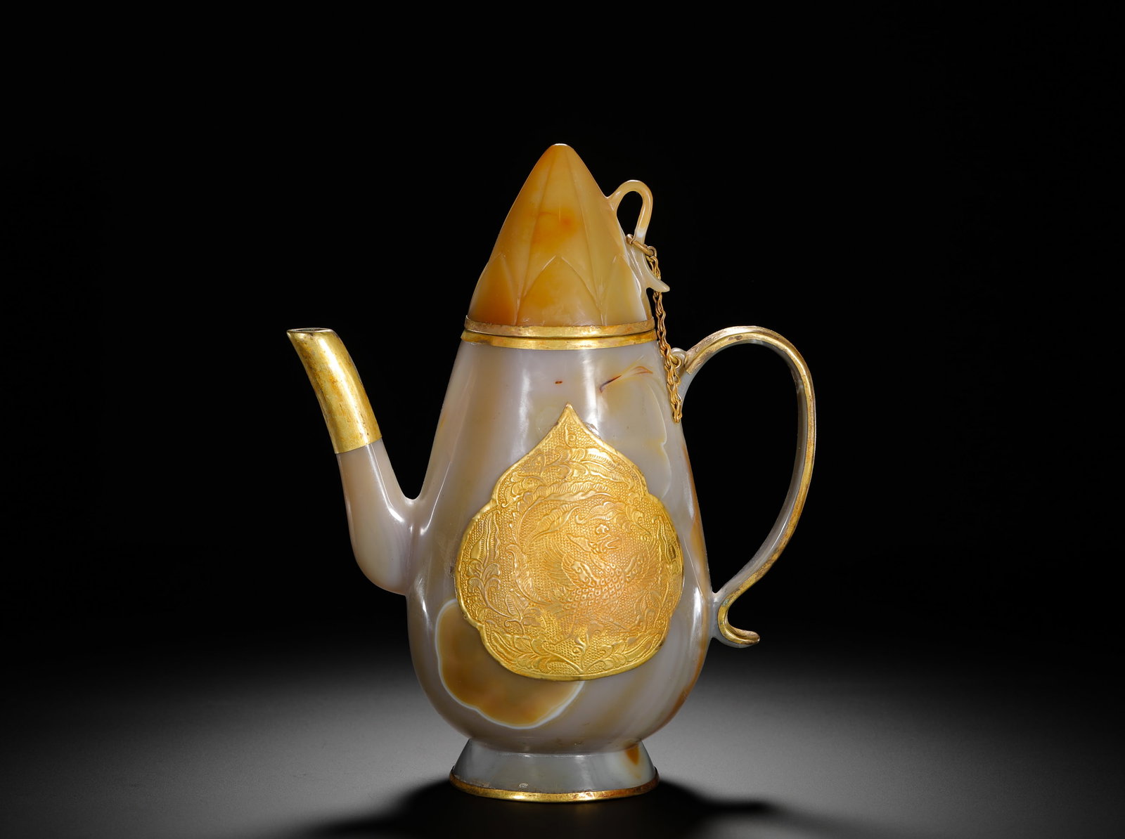 QING DYNASTY SILK AGATE WITH GOLD DRAGON PATTERN EWER: Height:21cm(8.27in) Width:17.5cm(6.89in) Weight:580g(1.28lb)Qing Dynasty banded agate wine pot with gilt dragon plaque. Solid hollowed agate carving with chain lid, full embossed double dragon relief 