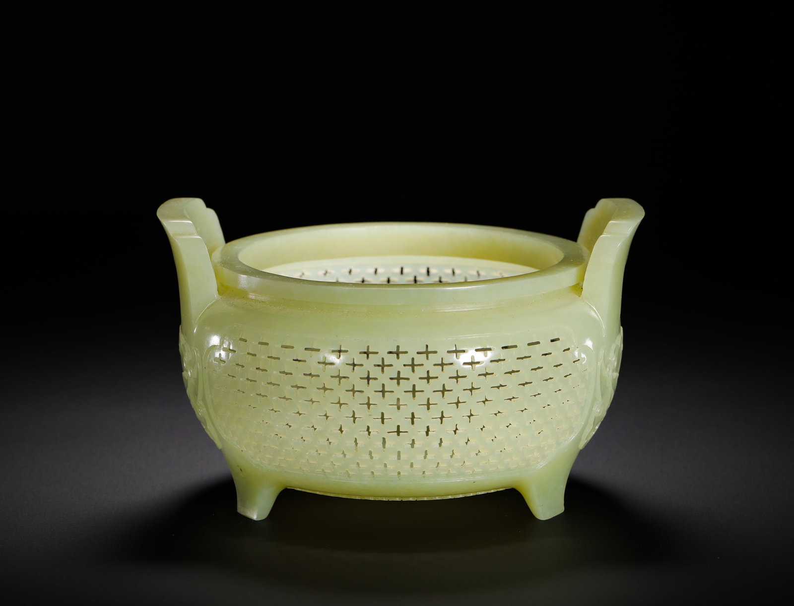 A THREE-LEGGED INCENSE BURNER OF HETIAN WHITE JADE FROM THE QING DYNASTY: Height:8cm(3.15in) Width:13cm(5.12in) Weight:270g(0.60lb)Hetian pale celadon jade hollow-cast incense burner, Qing imperial period. Carved integrally from a single large block of Hetian jade with soft