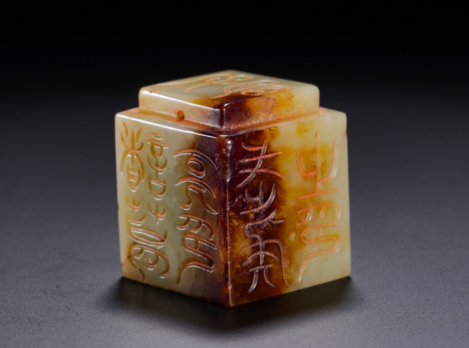 THE HETIAN JADE OF THE HAN DYNASTY WAS INSCRIBED WITH SQUARE SEALS ON ALL FOUR SIDES: Height:0.6cm(0.24in) Width:3.1cm(1.22in) Weight:100g(0.22lb)Carved from Hetian yellowish-green jade. Archaic seal characters are incised on four vertical sides and top surface, with a suspension apert
