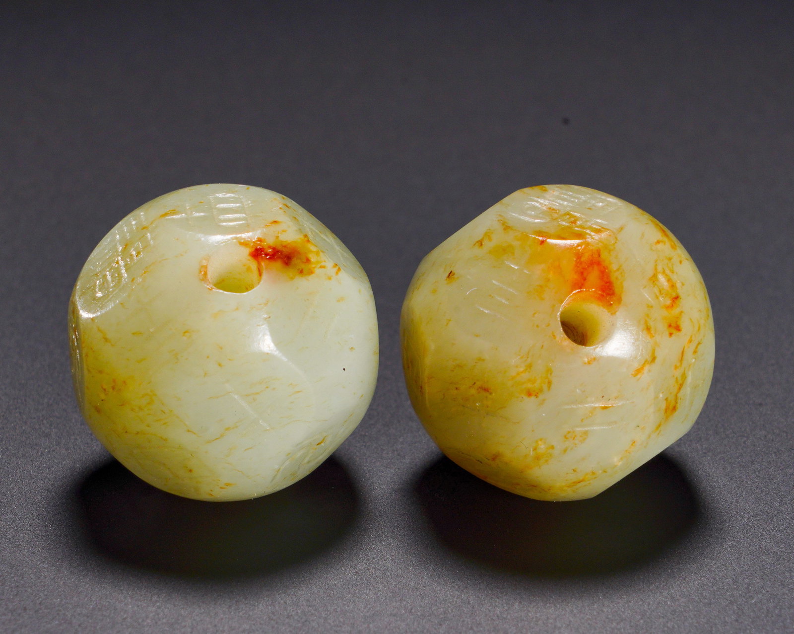 HAN DYNASTY HETIAN JADE DICE: Diameter:2cm(0.79in)Weight:20g(0.04lb)Ancient paired jade polygonal beads engraved with eight trigrams. The jade bears pale white base suffused with natural reddish-yellow aged patina. Each bead is cu