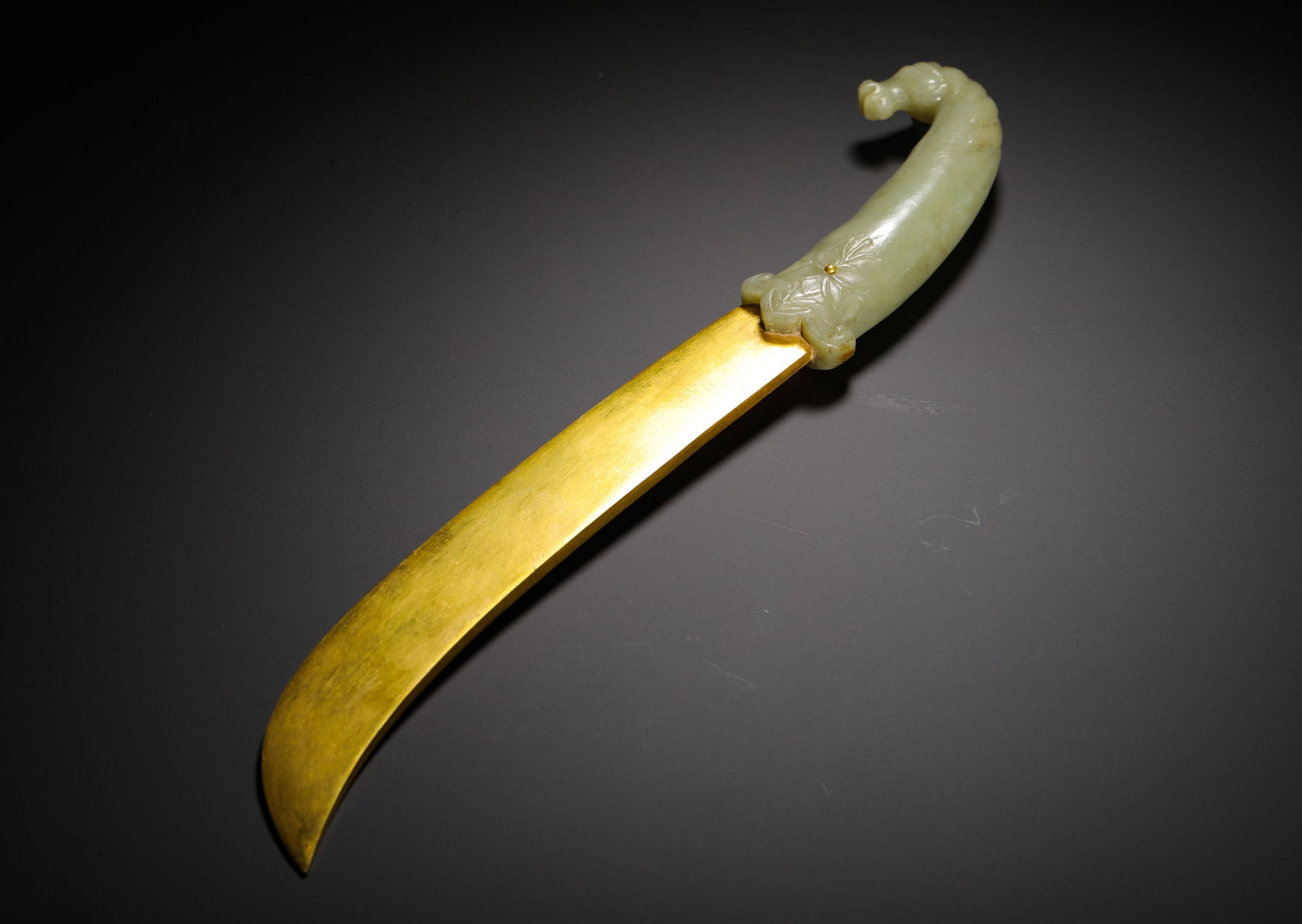 HAN DYNASTY HETIAN JADE BEAST HEAD FLOWER HANDLE GILT CURVED KNIFE: Long:36cm(14.17in) Weight:490g(1.08lb)Archaic Hetian celadon jade curved-handle knife with gilded blade.Integrally carved jade handle with mild texture and natural light brown aged veined patina. Curv
