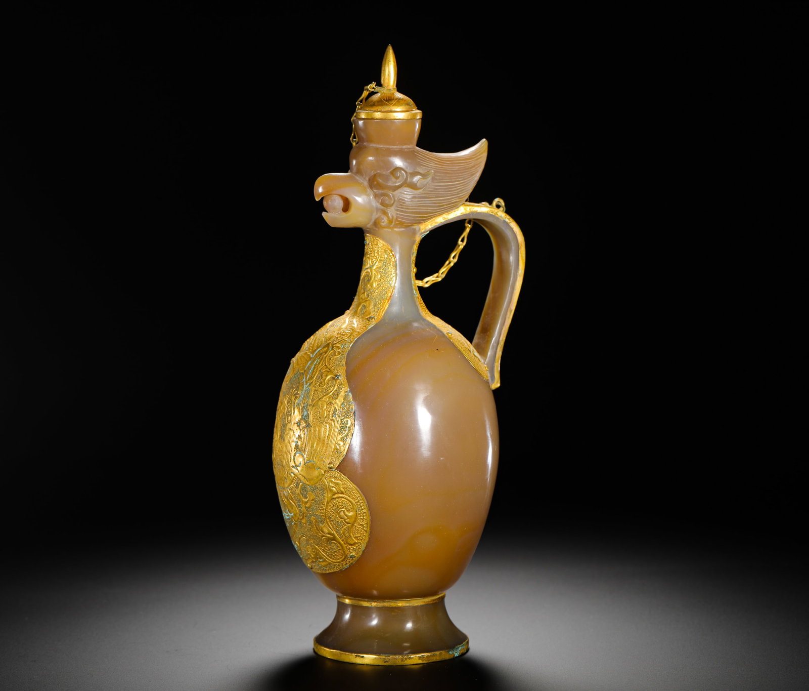 QING DYNASTY GILDED PHOENIX-HEAD EWER WRAPPED WITH SILK AGATE: Height:25cm(9.84in) Width:11cm(4.33in) Weight:560g(1.23lb)Qing Dynasty agate phoenix-head wine ewer inlaid with gilt handle and lid. Solid hollowed agate carving with natural orange-white banded silk 