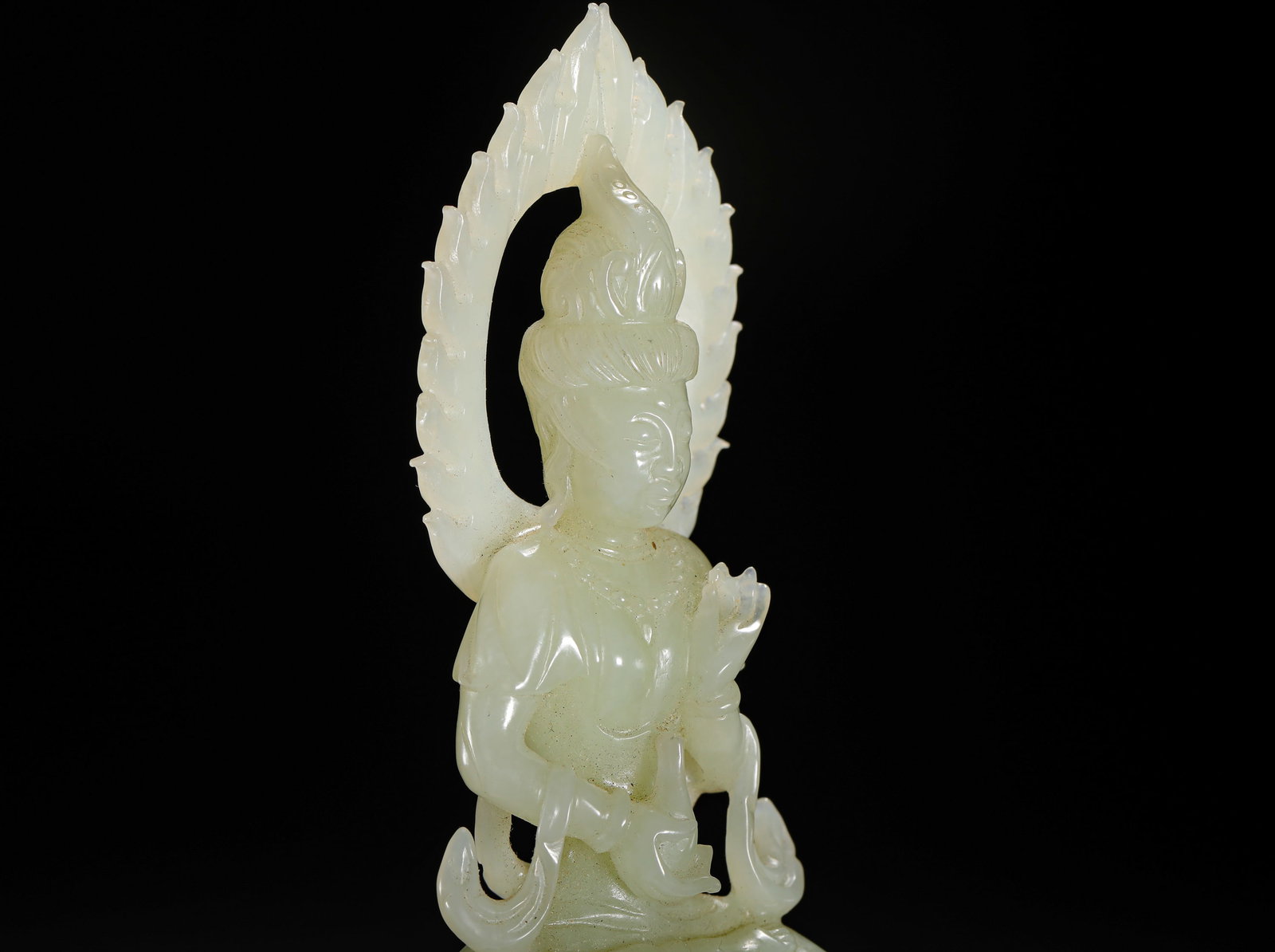 QING DYNASTY HETIAN JADE GUANYIN: Height:15cm(5.91in) Width:5cm(1.97in) Weight:200g(0.44lb)Qing Dynasty Hetian white jade seated Guanyin statue with hollowed flame halo. The Bodhisattva sits lotus posture holding pure vase with preach