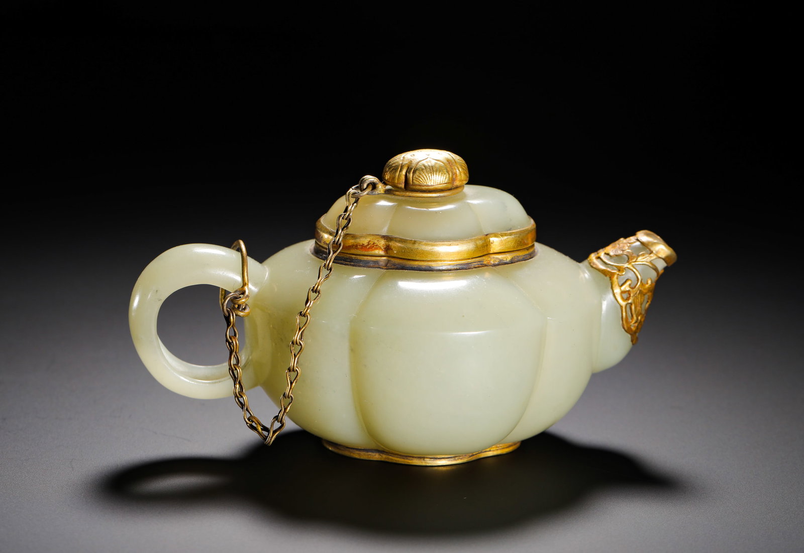 QING DYNASTY HETIAN JADE TEAPOT: Height:8cm(3.15in) Width:14cm(5.51in) Weight:190g(0.42lb)Hetian white jade melon-form teapot with gold mounting, Qing Dynasty.Creamy mild white jade with natural concentrated yellow russet patina.Four