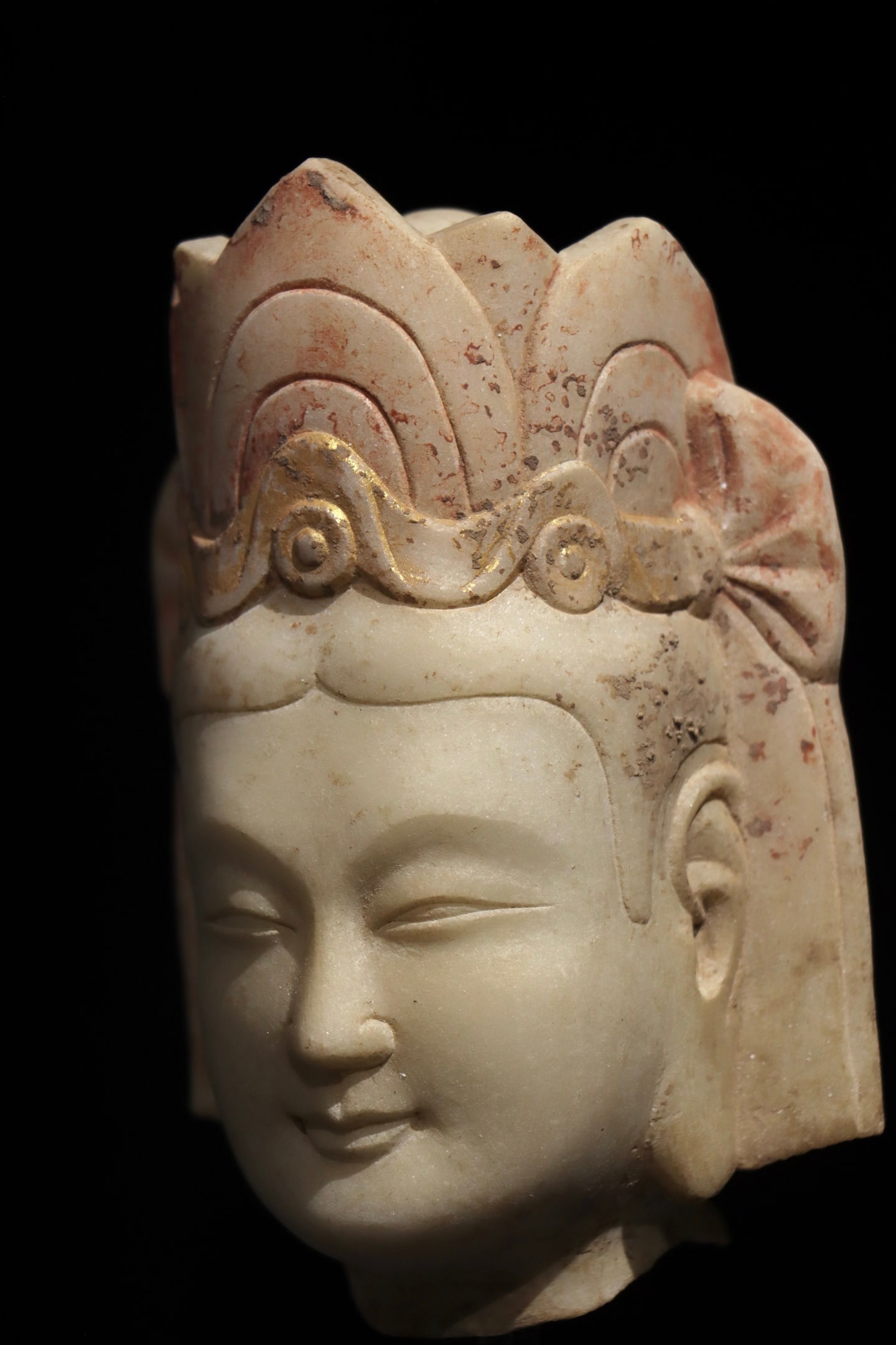 A GILDED AND PAINTED PORTRAIT OF GUANYIN BODHISATTVA ON WHITE MARBLE FROM THE NORTHERN QI DYNASTY: Dimensions without base Height:16cm (6.30in)White marble Guanyin Bodhisattva head painted with mineral pigments, traditional Chinese stone Buddhist sculpture.