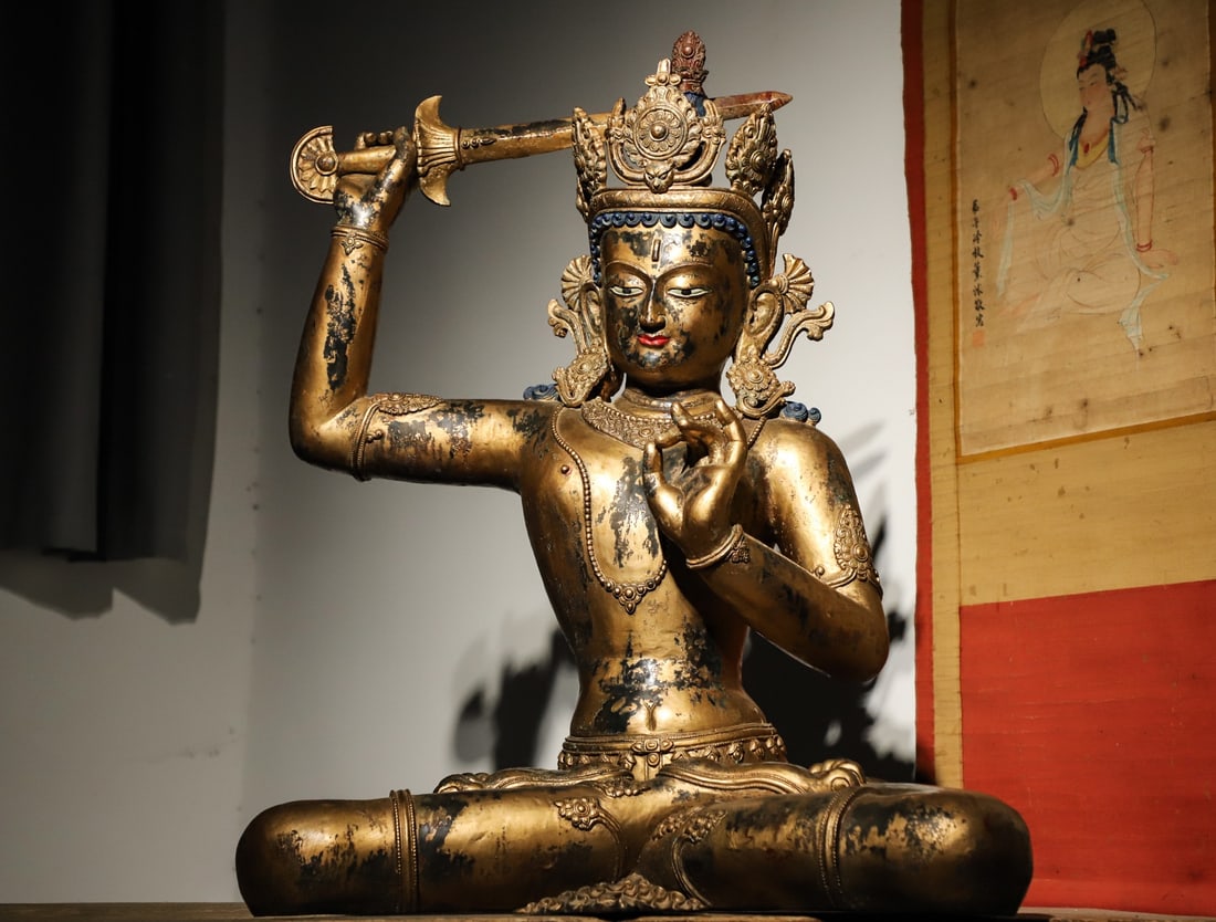 A GILDED BRONZE STATUE OF MANJUSRI BODHISATTVA HOLDING A SWORD FROM THE QING DYNASTY