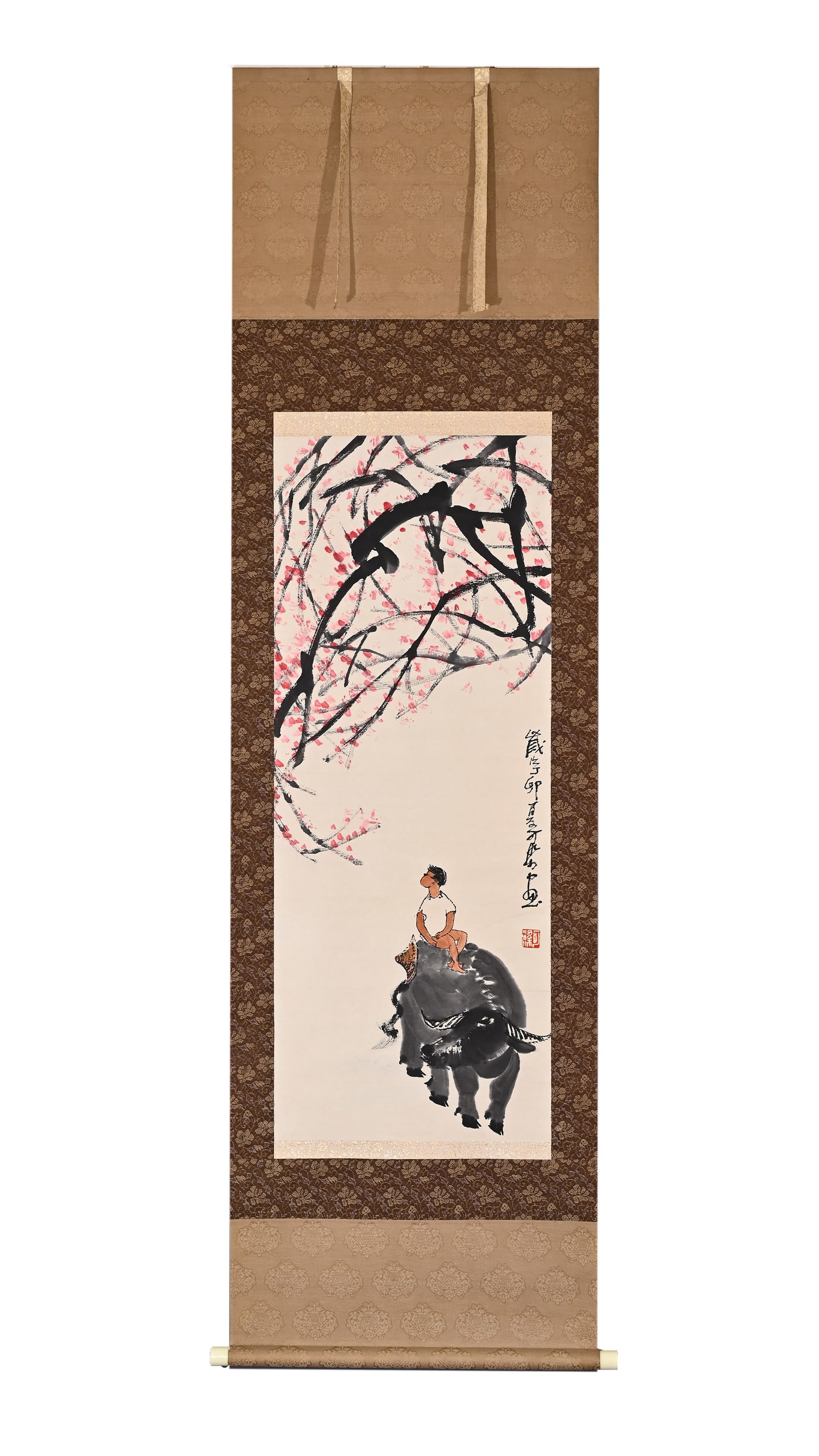 LI KERAN (1907-1989) STYLE CATTLE HERDING SCROLL: Height:102cm(40.16in) Width:40cm(15.75in)Cowherd painting scroll in Li Keran style. Pale ink painting of boy sitting on buffalo, red plum blossoms above, signature and seal on right, antique patterned