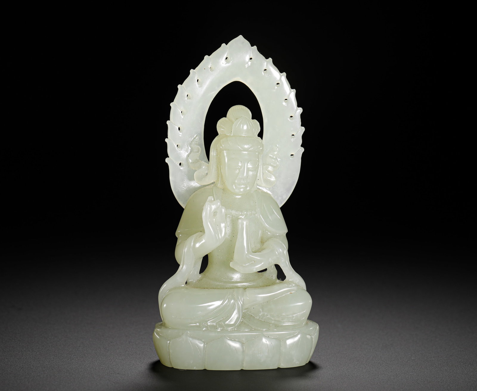 SEATED STATUE OF GUANYIN IN A PURE VASE MADE OF HETIAN JADE FROM THE QING DYNASTY: Height:12cm(4.72in) Width:6cm(2.36in) Weight:200g(0.44lb)Qing Dynasty Hetian white jade seated Guanyin statue with hollowed flame halo. The Bodhisattva sits lotus posture holding pure vase with preach